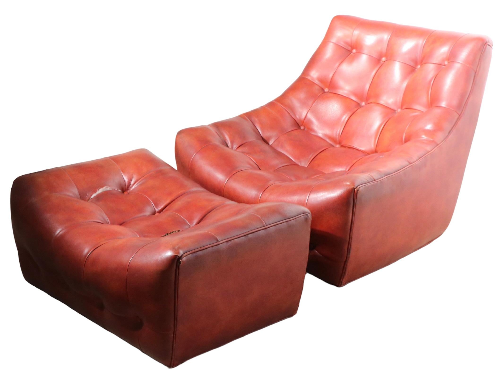 Rare scoop form lounge chair and ottoman designed by Milo Baughman, produced by Thayer Coggin, circa 1970's. The chair is upholstered in faux leather vinyl, with button tufted surfaces, the ottoman shows two splits at the seams - please see images.
