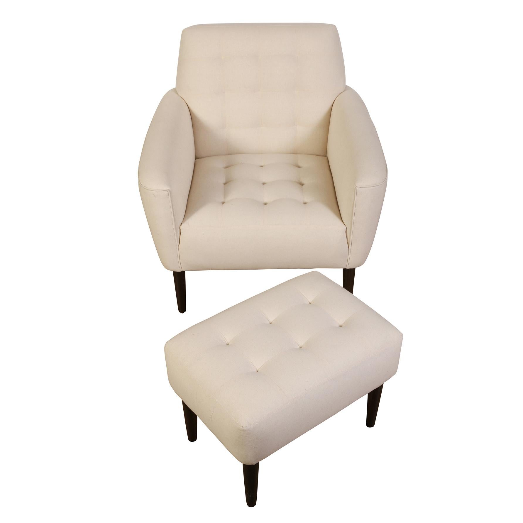 A chic mid-century arm chair with a tight, button tufted back and seat, accompanied by a button tufted ottoman.  Very comfortable, this duo has been reupholstered in a crisp white linen, accentuating the clean lines of the pieces.