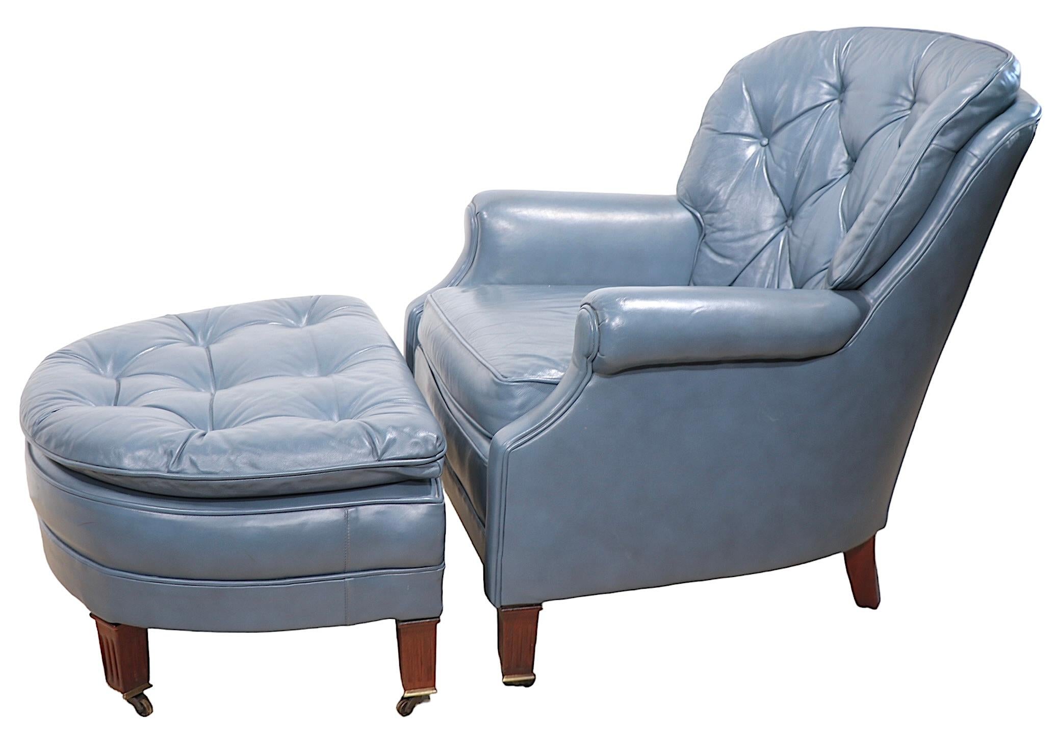 Chic, sophisticated and comfortable, leather lounge chair, with matching ottoman by Classic Leather circa 1950/1960's. The chair and ottoman feature  intriguing dark tone blue leather upholstery, with solid wood fluted tapering less, and cast metal