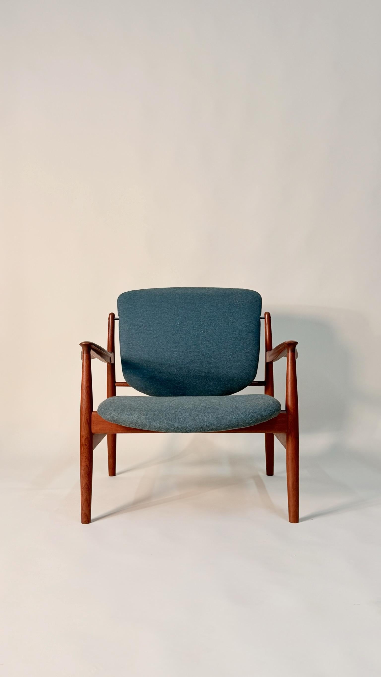 Finn Juhls Sessel Modell 136 für France & Son. Wunderschön geformtes Teakholzgestell mit klassischen Finn Juhl Designelementen: ein schwebender Sitz und eine schwebende Rückenlehne sowie feine Armlehnen. Dieser Stuhl hat eine neue Polsterung und