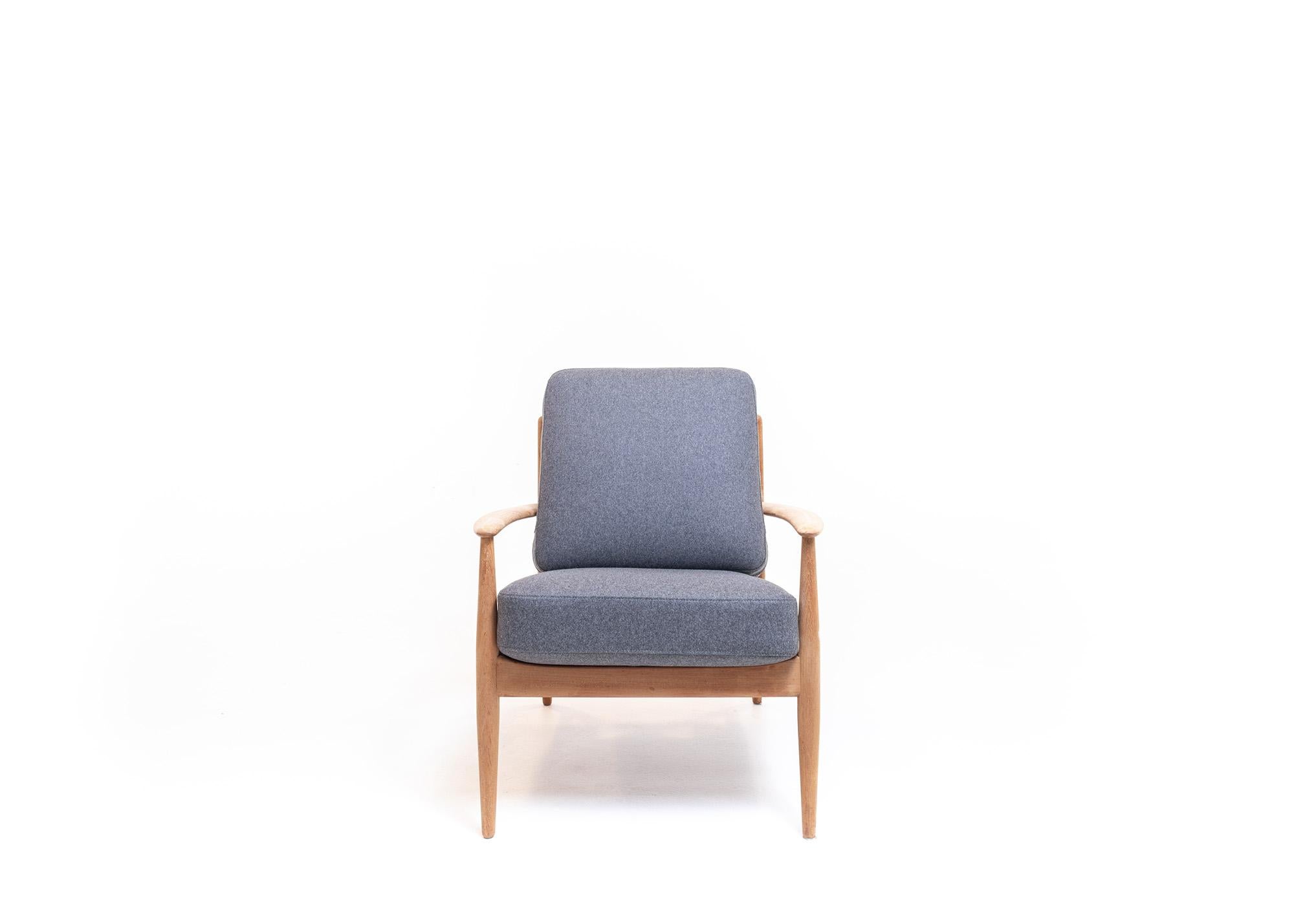 A stunning Mid-Century Modern piece designed by renowned Danish designer Grete Jalk for France & Søn. Made from solid oak wood, this lounge chair displays a sense of sophistication and elegance that is characteristic of Mid-Century Modern