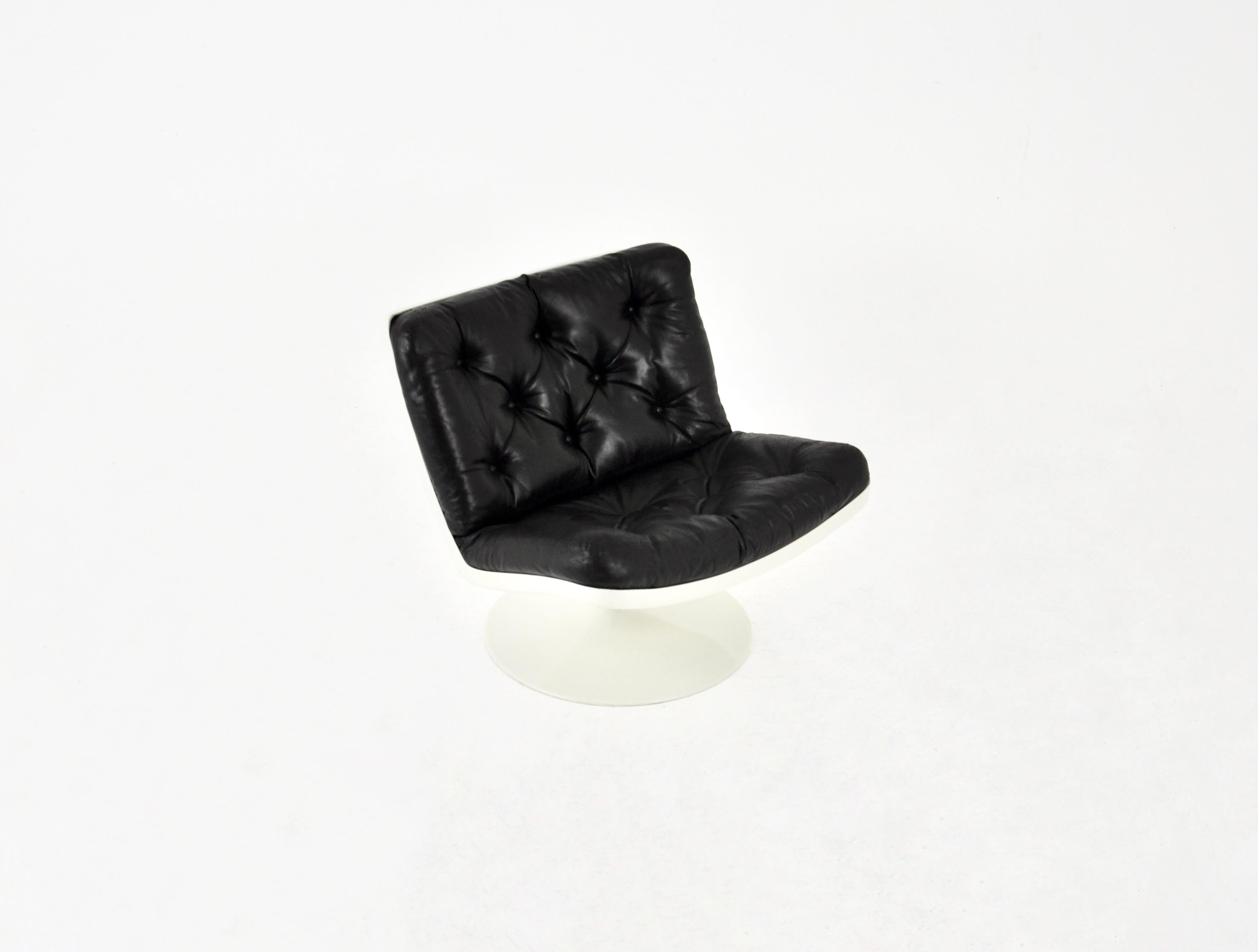 Fauteuil pivotant en cuir noir et coque en plastique. Hauteur du siège 43 cm. Usure due au temps et à l'âge.