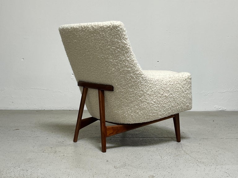 A lounge chair with sculpted walnut base designed by Jens Risom. Fully restored and upholstered in Holly Hunt / Teddy / Winter White.