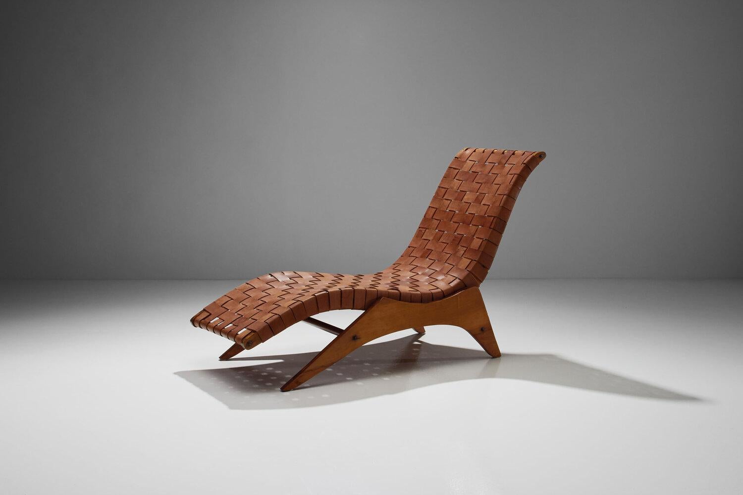 This rare José Zanine Caldas lounge chair is an exceptional example of Brazilian design of the 1950s. The woven leather straps and the organic shape is unmatched.

This large lounge chair is made of plywood and features a distinctive, curved