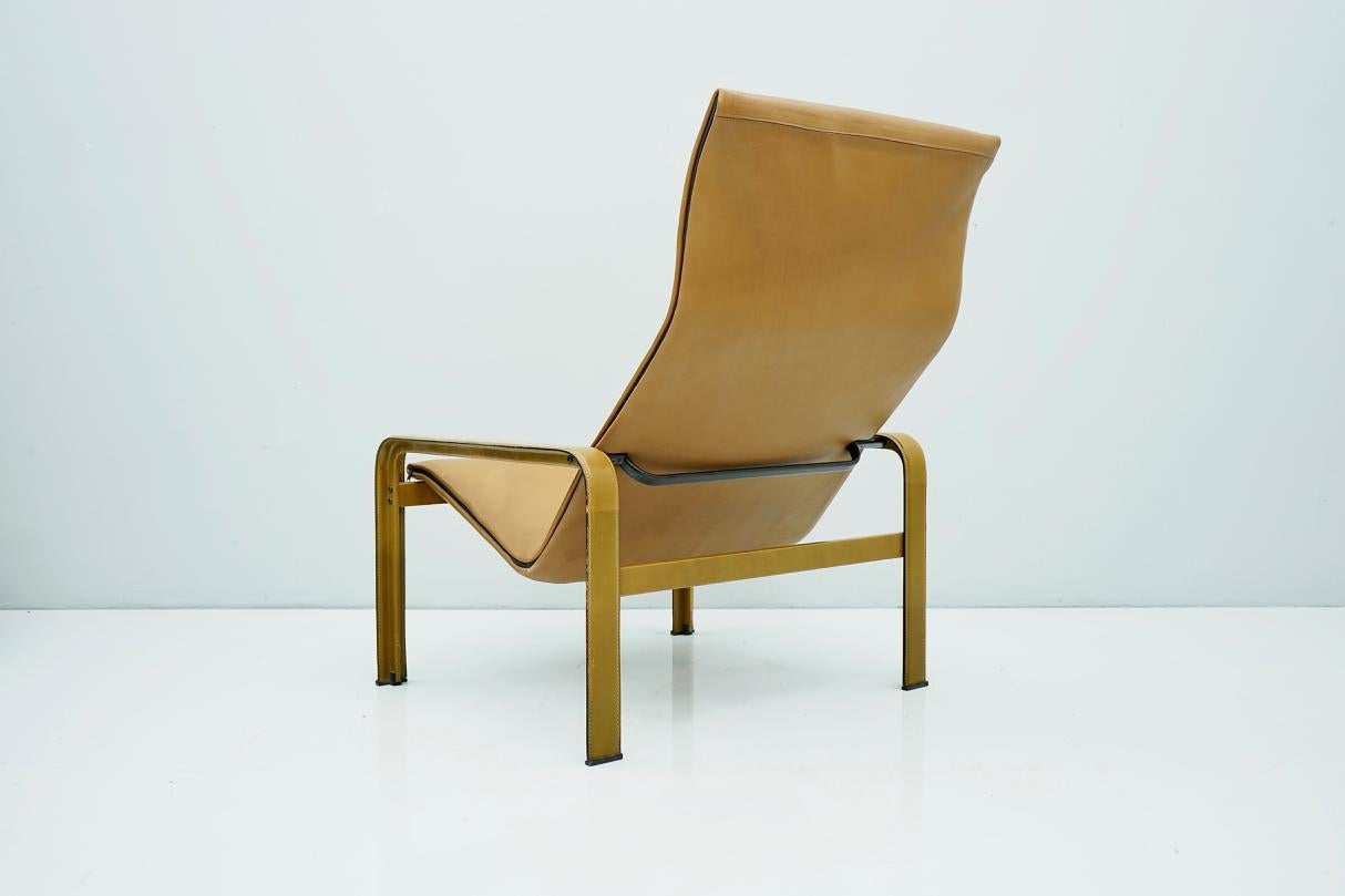High back chair, in cognac brown leather and metal by Matteo Grassi, Italy, 1970s. Modern minimalistic high back lounge chair by Italian designer Matteo Grassi. This high back armchair has an interesting and inventive construction. The chair consist