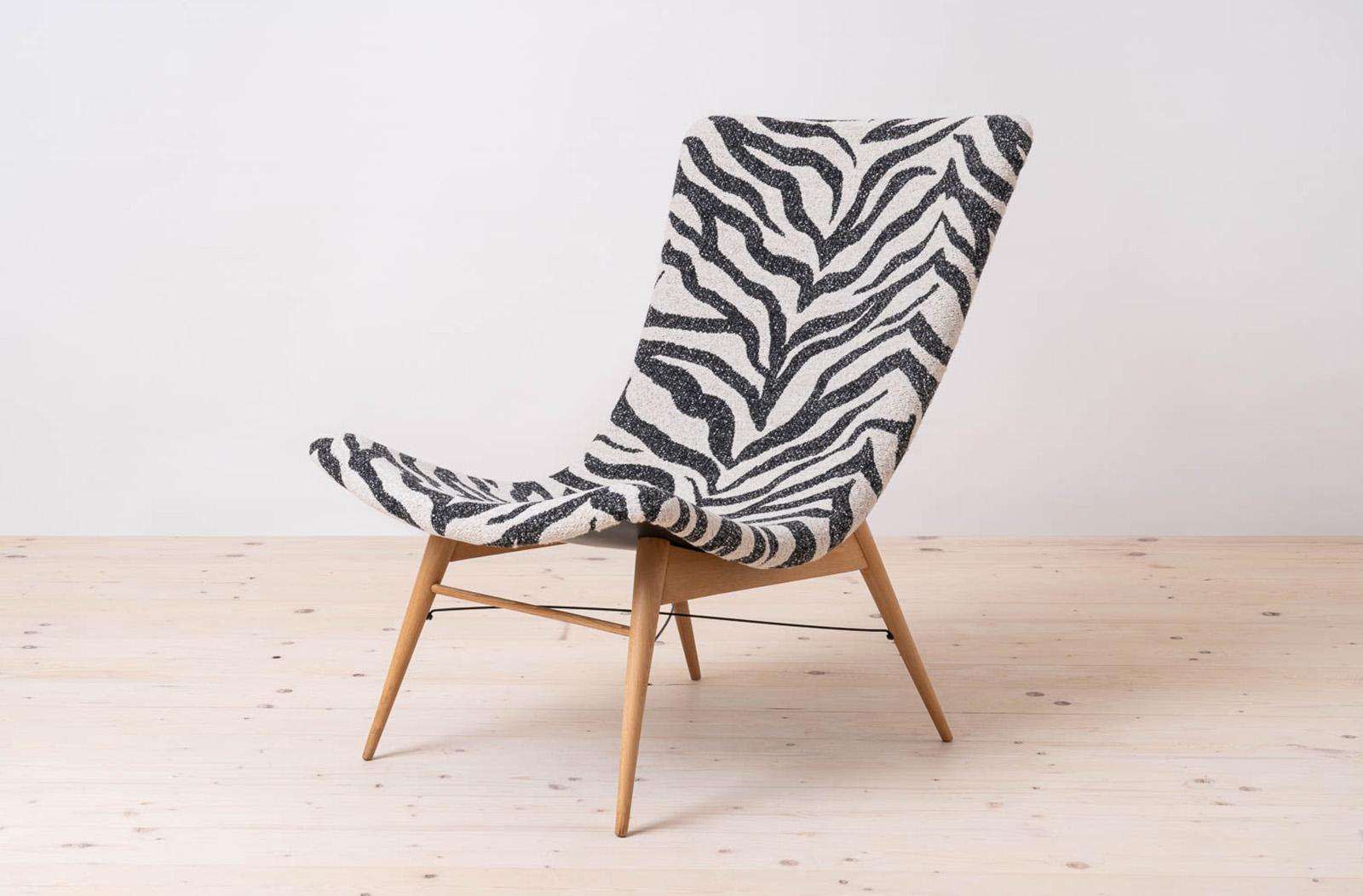 This vintage lounge chair was designed by Miroslav Navratil and manufactured in former Czechoslovakia by Cesky Nabytek in 1959. It is a timeless piece of mid-century modern design. Featuring an original wooden base and a fiberglass shell seating,