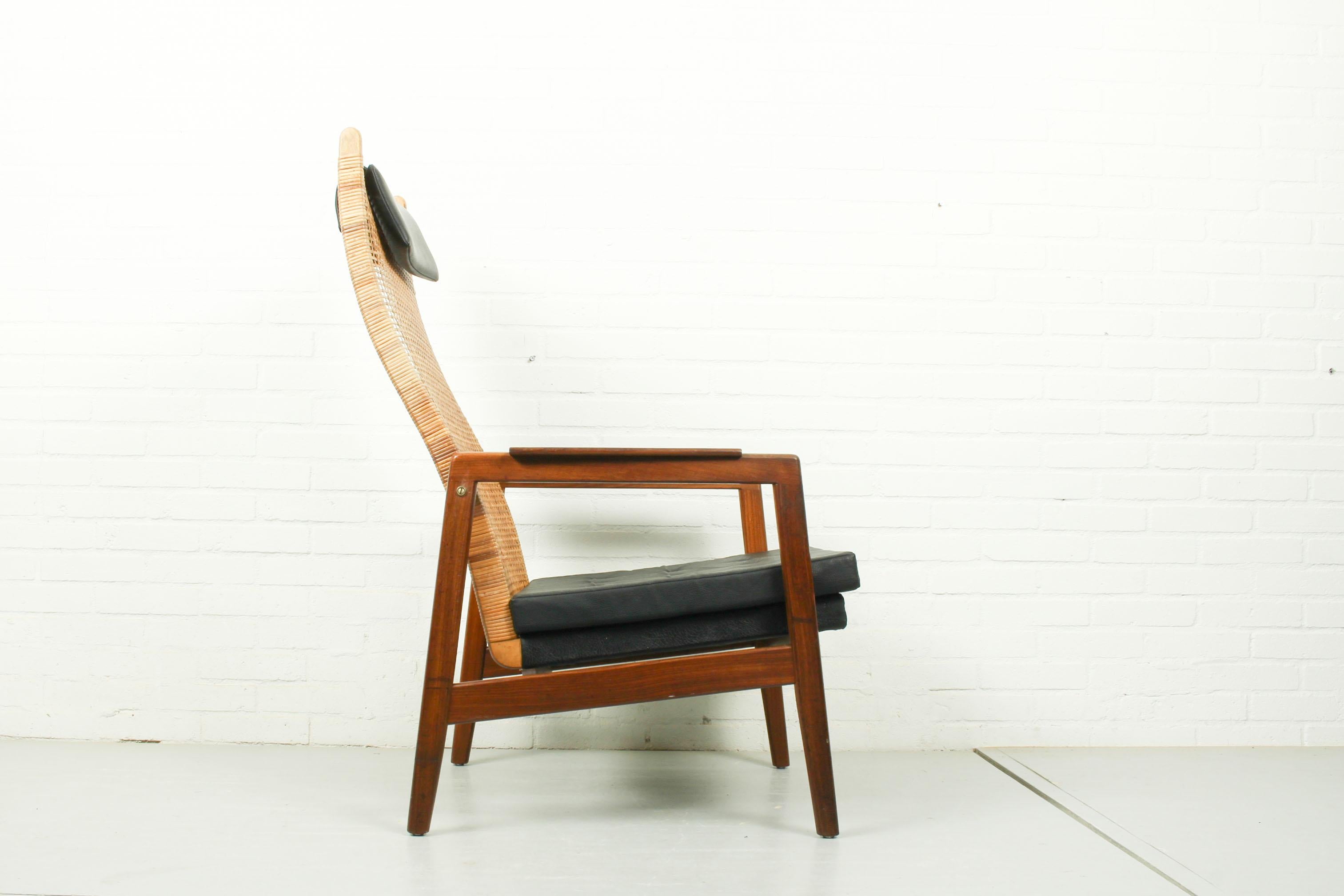 Lounge chair designed by Muntendam for Gebroeders Jonkers, 1960s. The chair has a teak frame, a webbed cane backrest and vinyl leather upholstery. It is fully original and overall in good vintage condition althought there seem to have been some