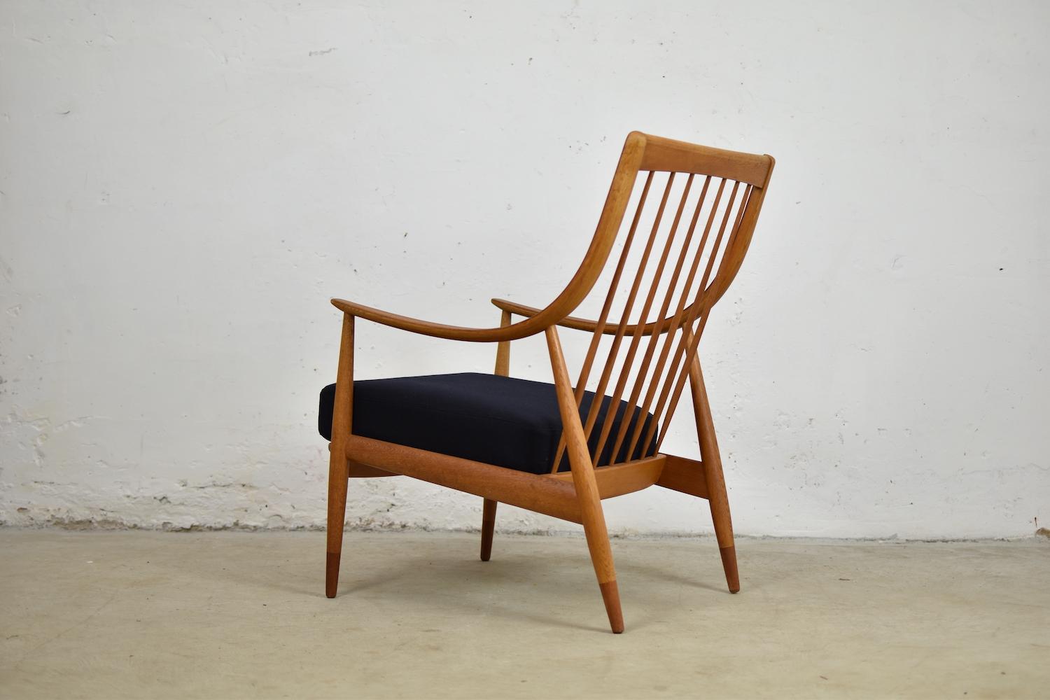 Lounge chair by Peter Hvidt and Orla Mølgaard Nielsen for France & Søn, Denmark, 1953. This chair features an oak and teak frame with freshly reupholstered wool cushions by Stephan Schneider. Nice curved armrests and a spindle backrest!