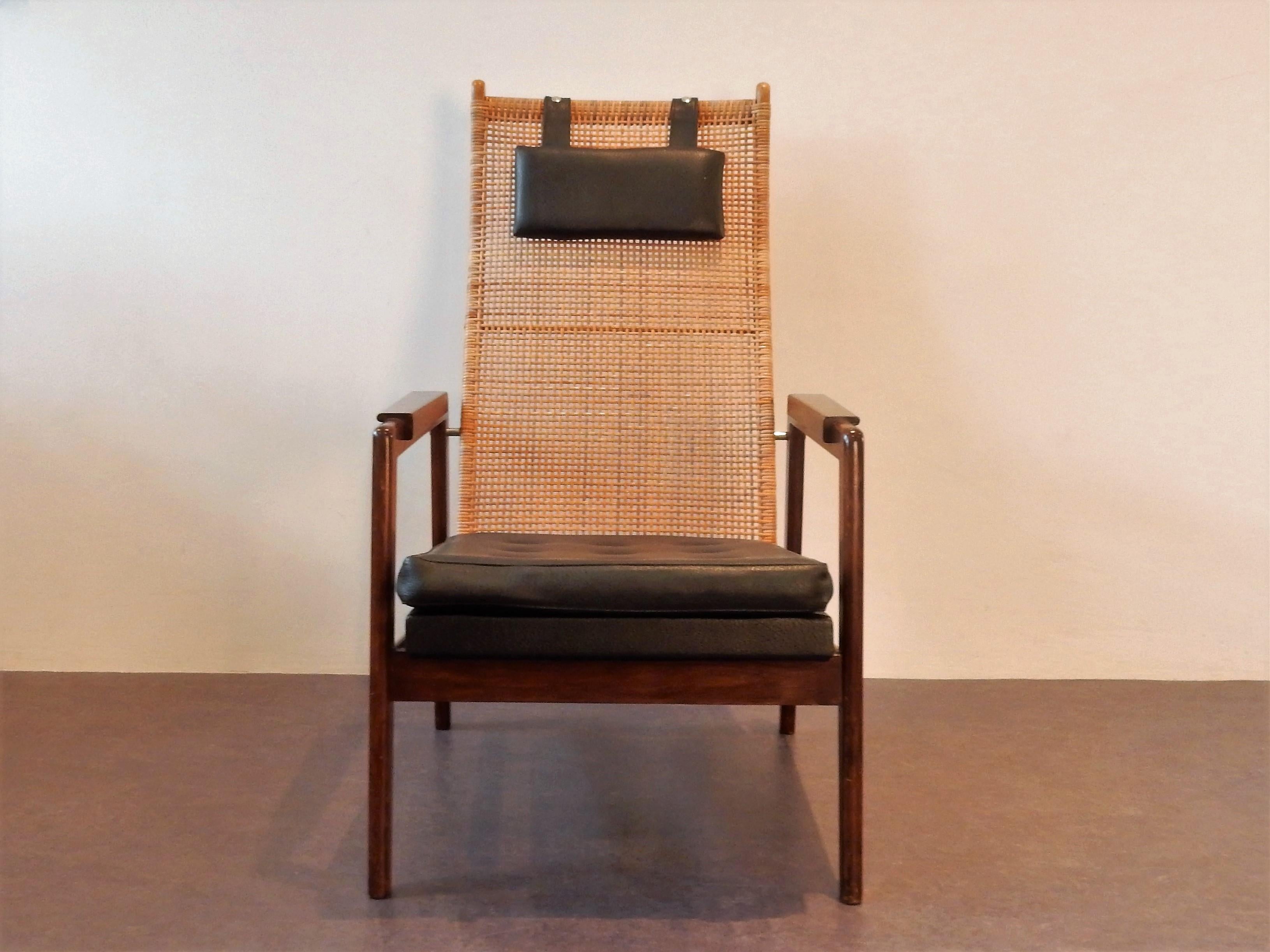Cette chaise longue a été conçue par P.J. Muntendam pour Gebroeders Jonkers ou en anglais, les frères Jonkers. Les frères Jonkers étaient célèbres pour leurs chaises et meubles en rotin. Cette chaise a un dossier en rotin, des coussins en cuir de