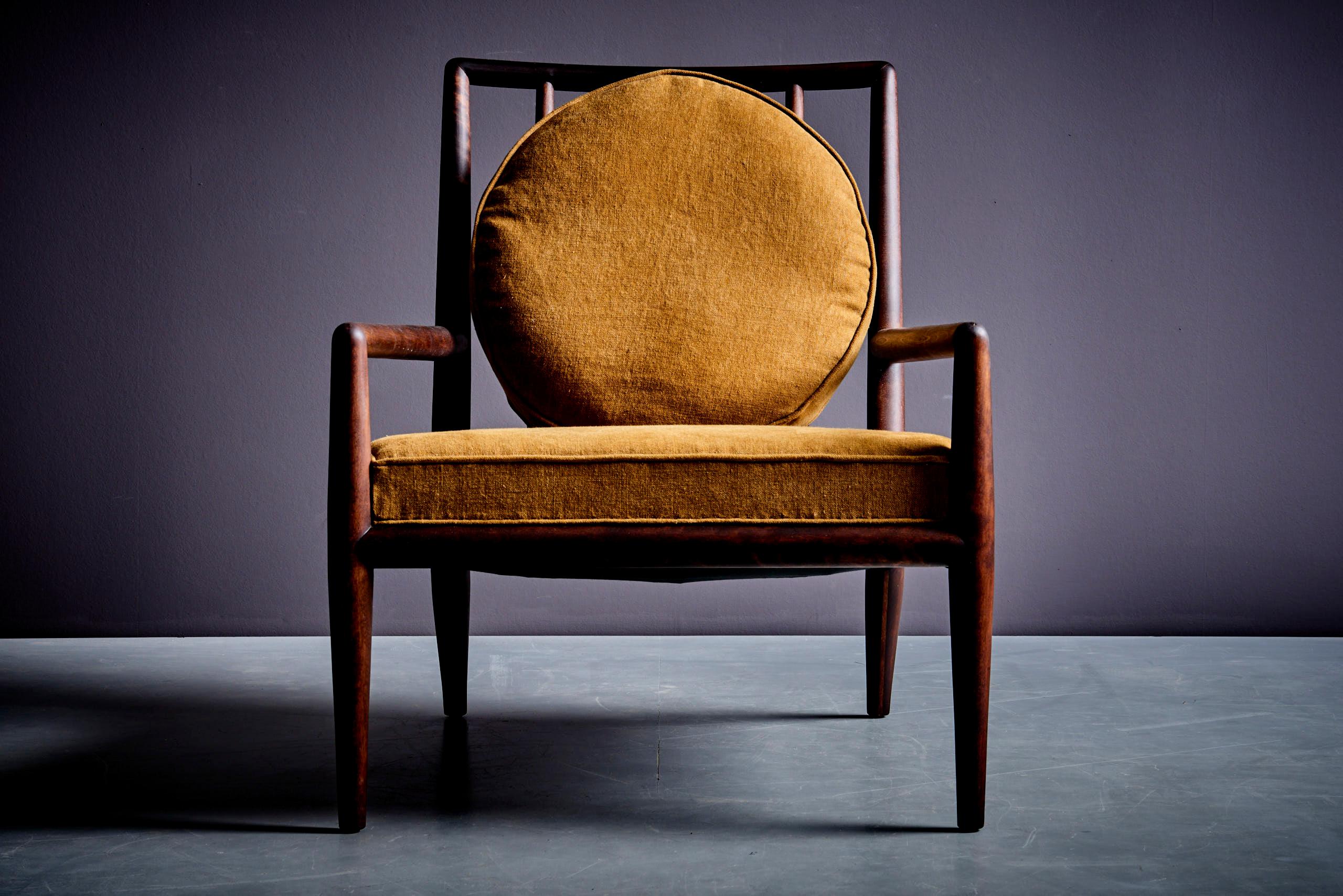This elegant lounge chair, designed by T.H. Robsjohn-Gibbings for Widdicomb in the mid-1950s, exemplifies the finest in mid-century design. Widdicomb, known for its premium craftsmanship, created this chair with a solid, sculpted walnut-stained
