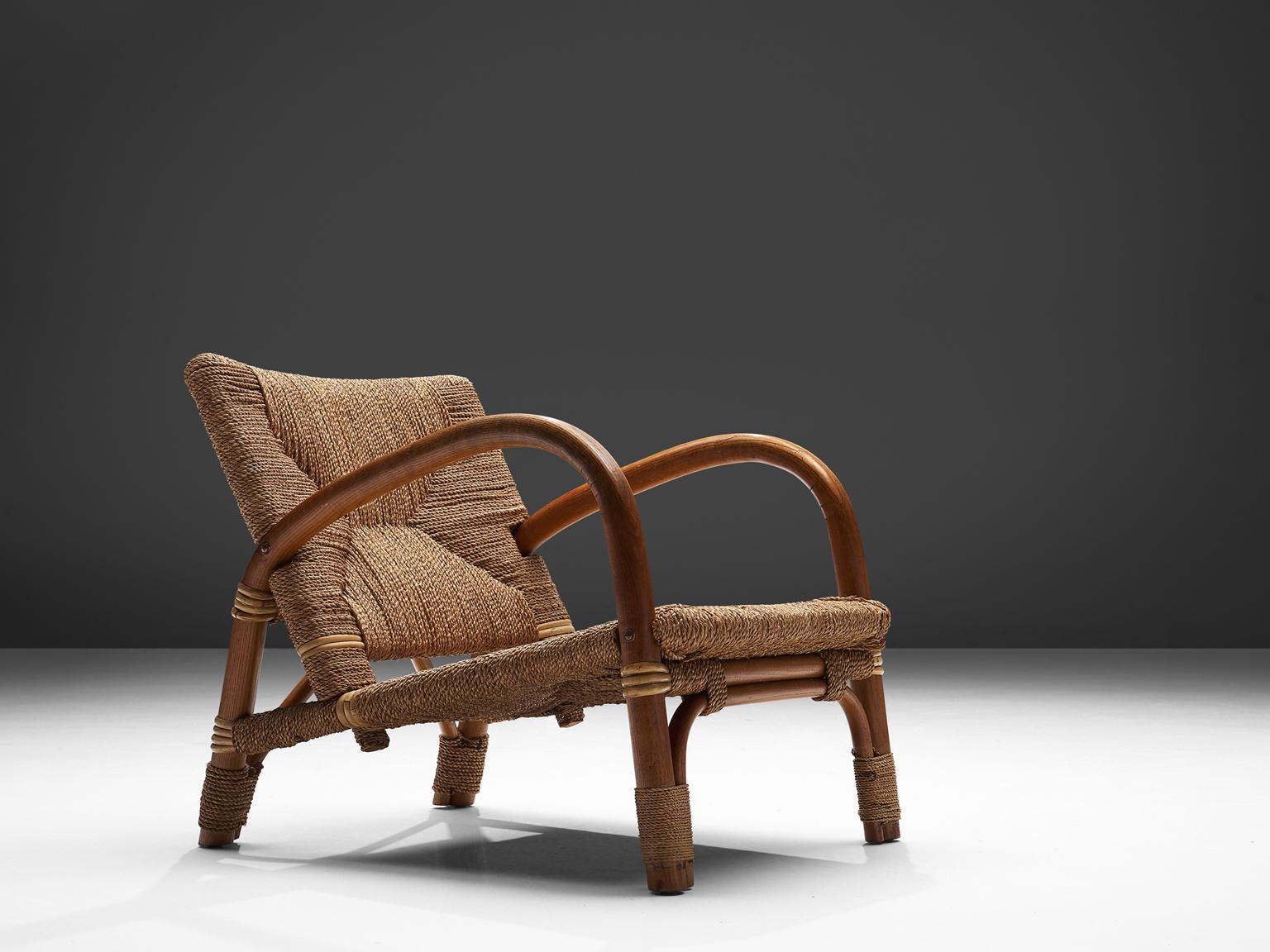Wicker armchair, cane and beechwood, Netherlands, 1960s.

This well designed lounge chairs has an open character. The warm expression of the two materials combined work well. The woven cane upholstery shows beautiful details. The cane is used both