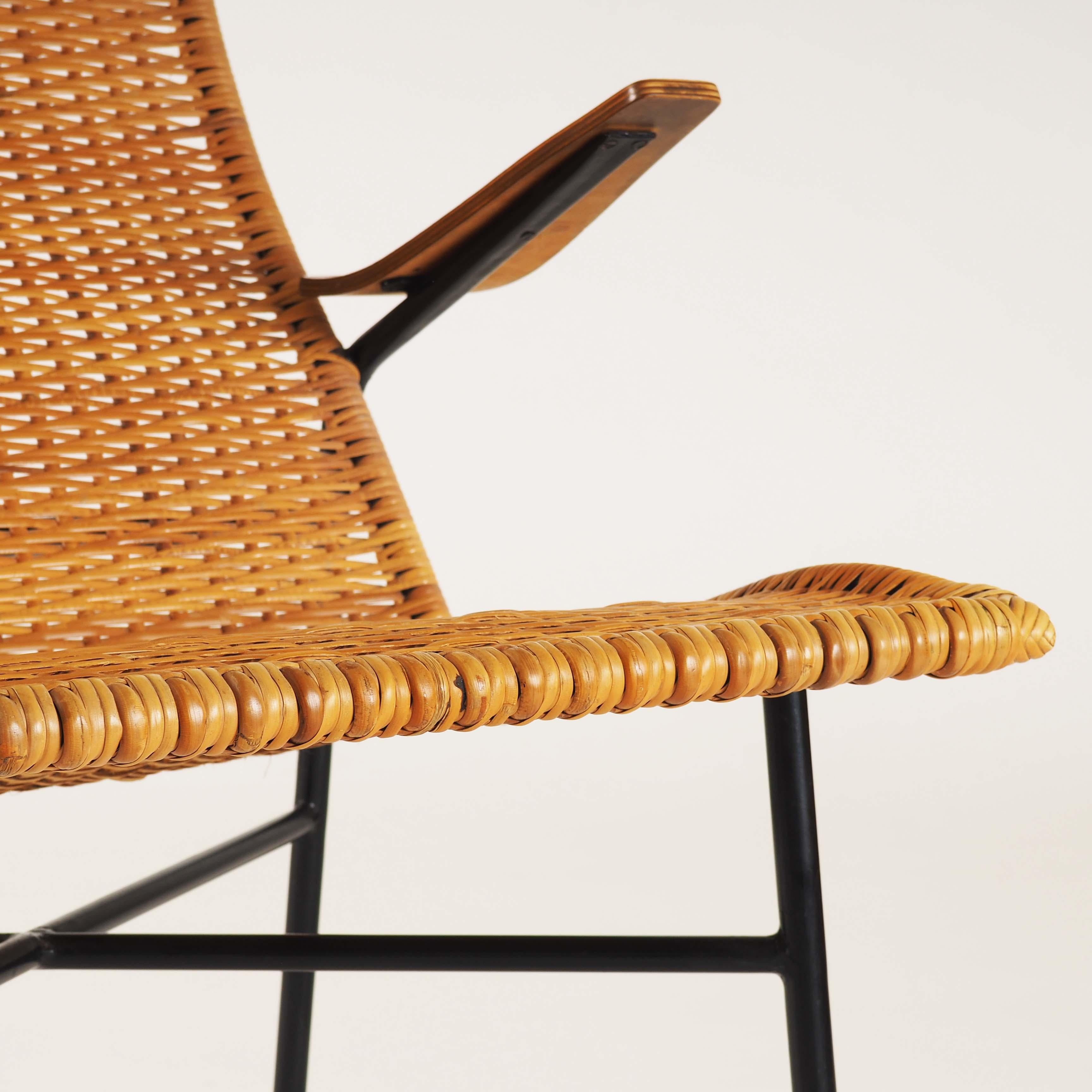 Elegant and rare lounge chair in rattan, teak and metal.