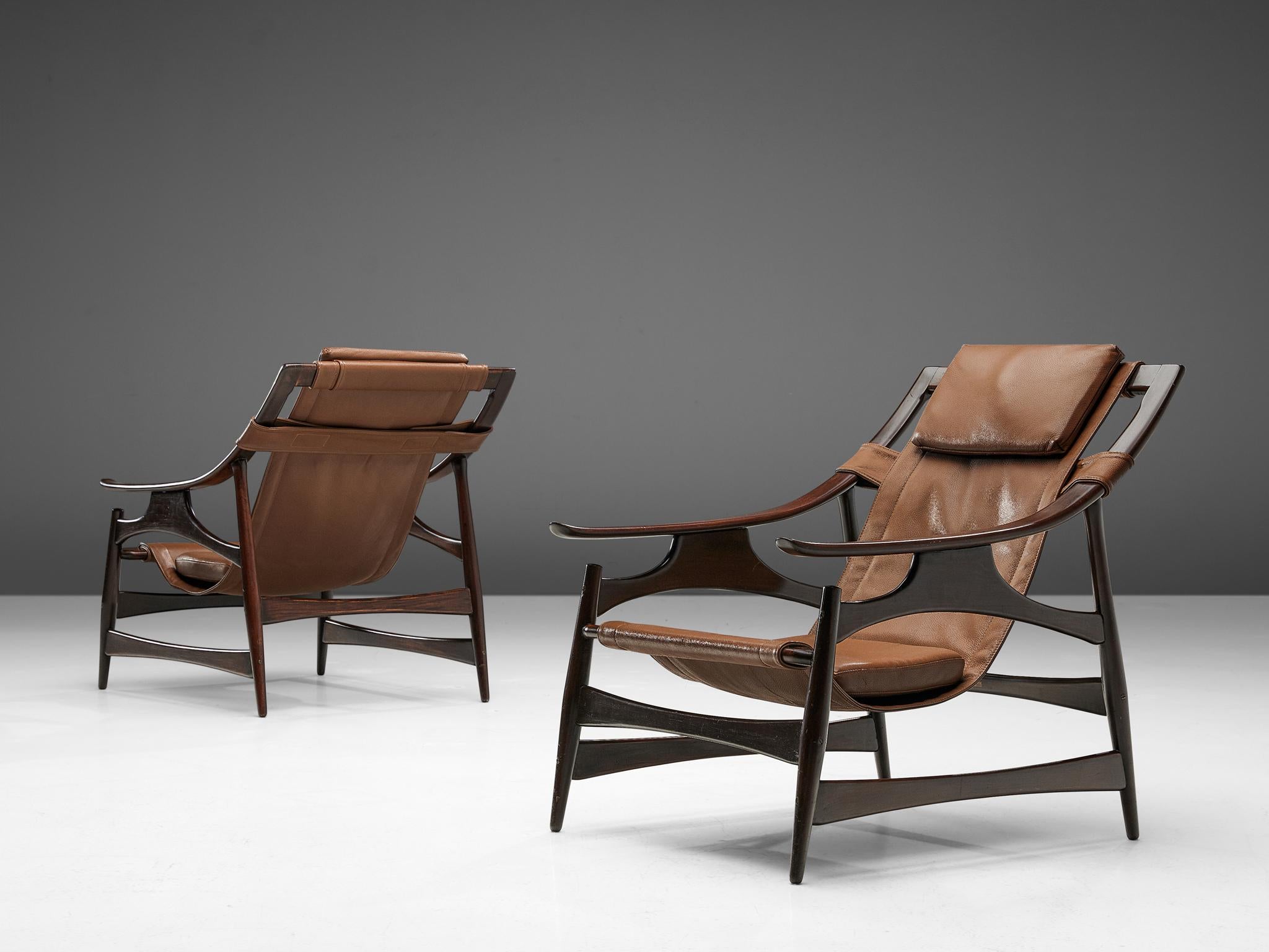 Liceu de Artes e Oficios, lounge chair, darkened embuia wood and leather, Brazil, 1960s. 

Beautiful lounge chair in dark Brazilian walnut with a brown leather  upholstery. The frame is a sort of wooden skeleton. It has an open character with