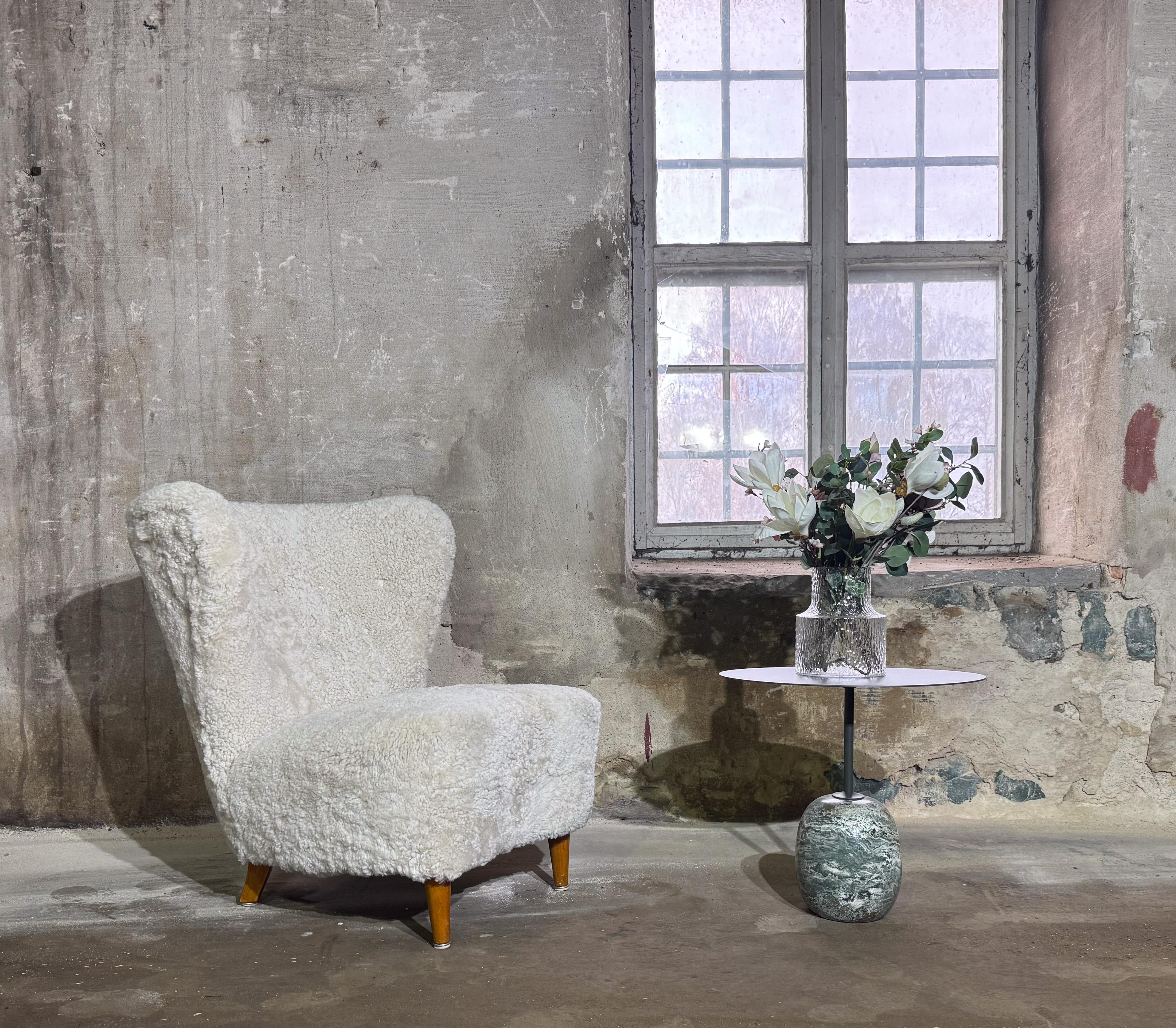 A lovely lounge chair designed by Johannes Brynte at Bryntes Furnitures in Sweden. The chair is newly reupholstered in our own upholstery workshop with moonlight sheepskin. The chair comes with original varnished beech legs, the seat height is 38 cm