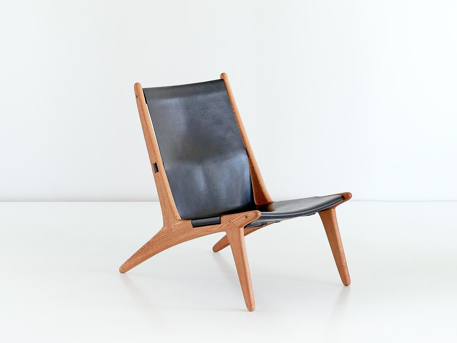 This striking lounge chair was designed by Uno and Östen Kristiansson and manufactured by Luxus AB in Vittsjö, Sweden from 1954 onwards. The design of this model numbered 204 is often referred to as a hunting chair. The frame is made of solid oak