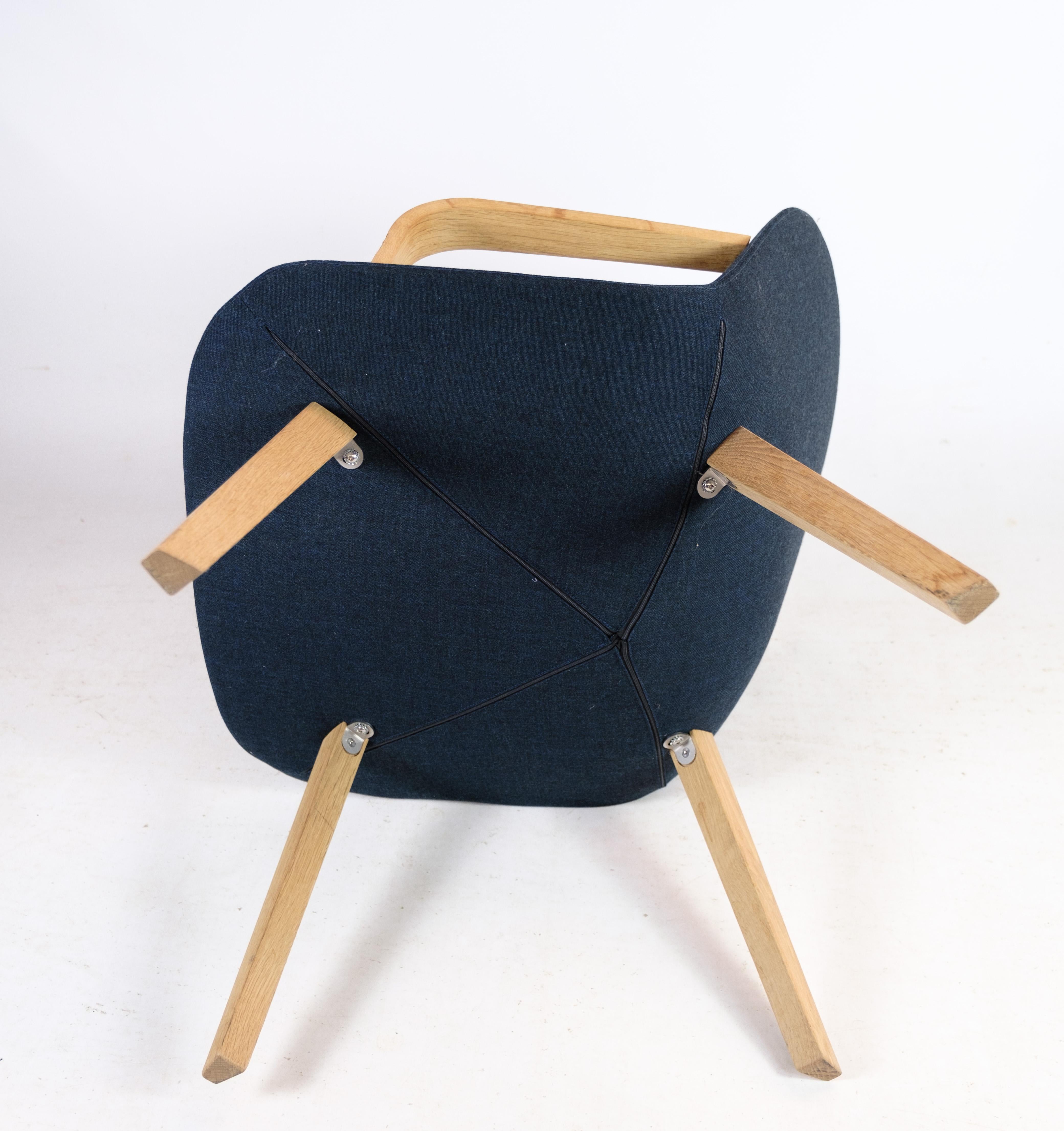 The lounge chair, model EJ 3, meticulously crafted in oak with luxurious blue wool fabric by Erik Jørgensen, as part of the esteemed Eyes series. This exquisite chair seamlessly blends contemporary design with timeless comfort, making it an ideal