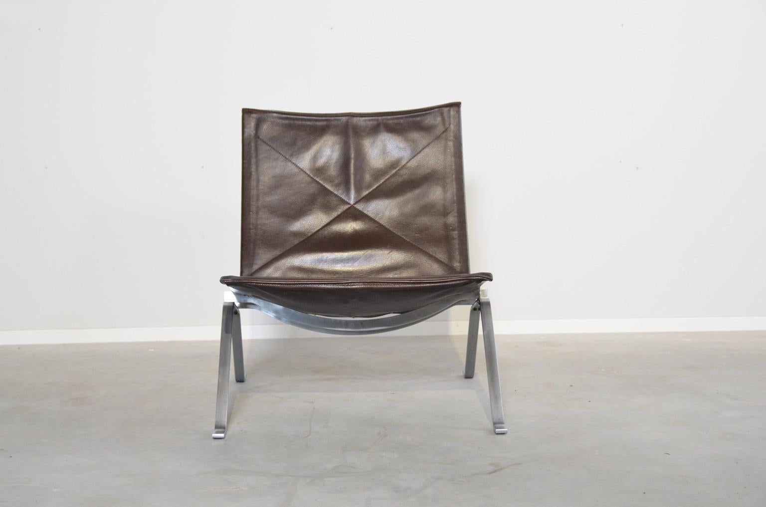 Beautiful patinated darkbrown leather version of the famous PK22 chair. The PK22 lounge chair was an immediate success at the introduction in 1956. The chair embodies Poul Kjaerholm's search for the ideal balance between form and function. The chair