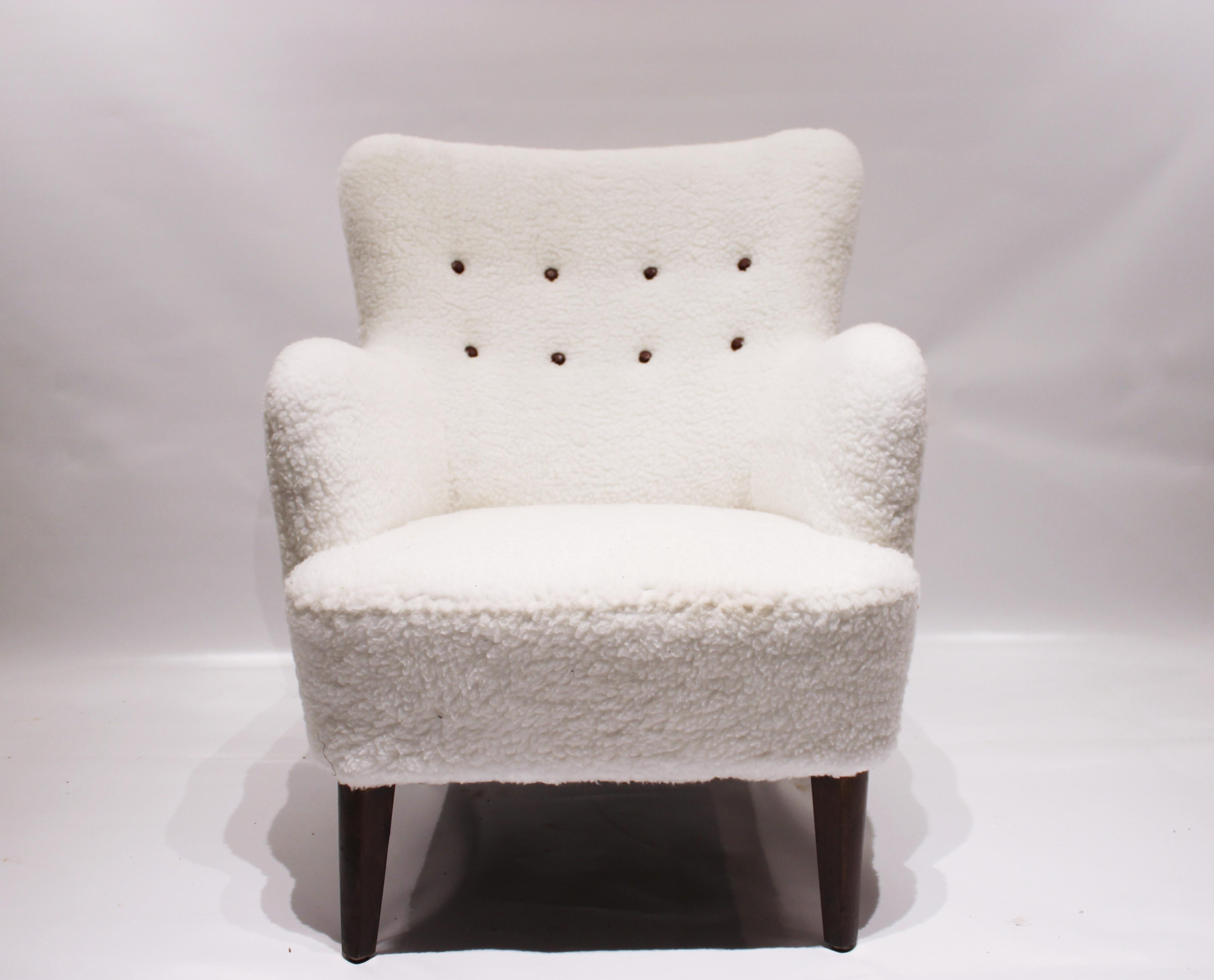 Lounge chair upholstered with white wool fabric and leather buttons, and legs of mahogany. The chair is of Danish design from the 1930s and in great vintage condition.