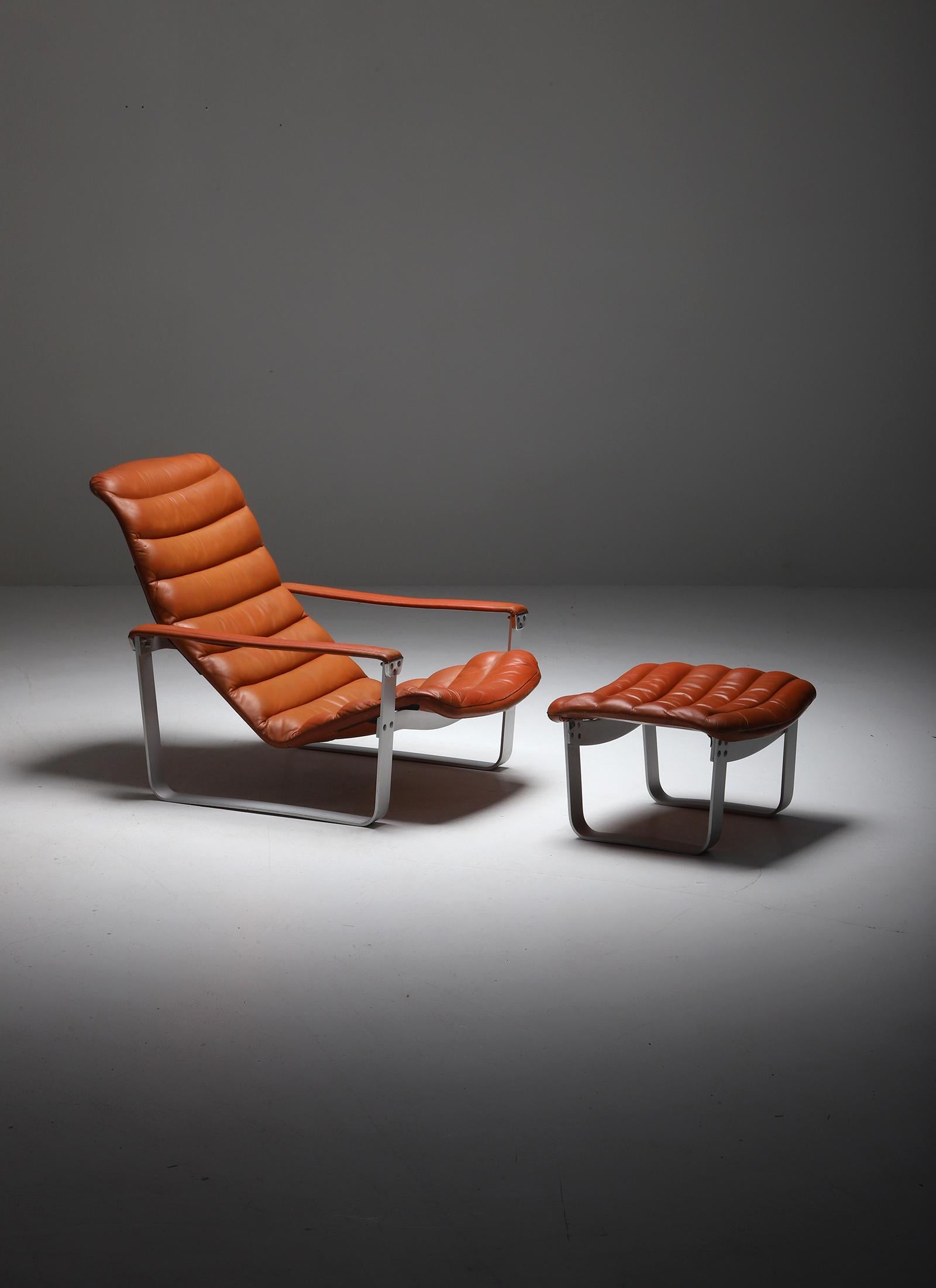 Lounge chair with Ottoman designed by Ilmari Lappalainen For Asko 1960s. Both items have an aluminum base and are upholstered in a dark cognac, brown gradient color leather, which has gained a beautiful patina over the years. The seating is