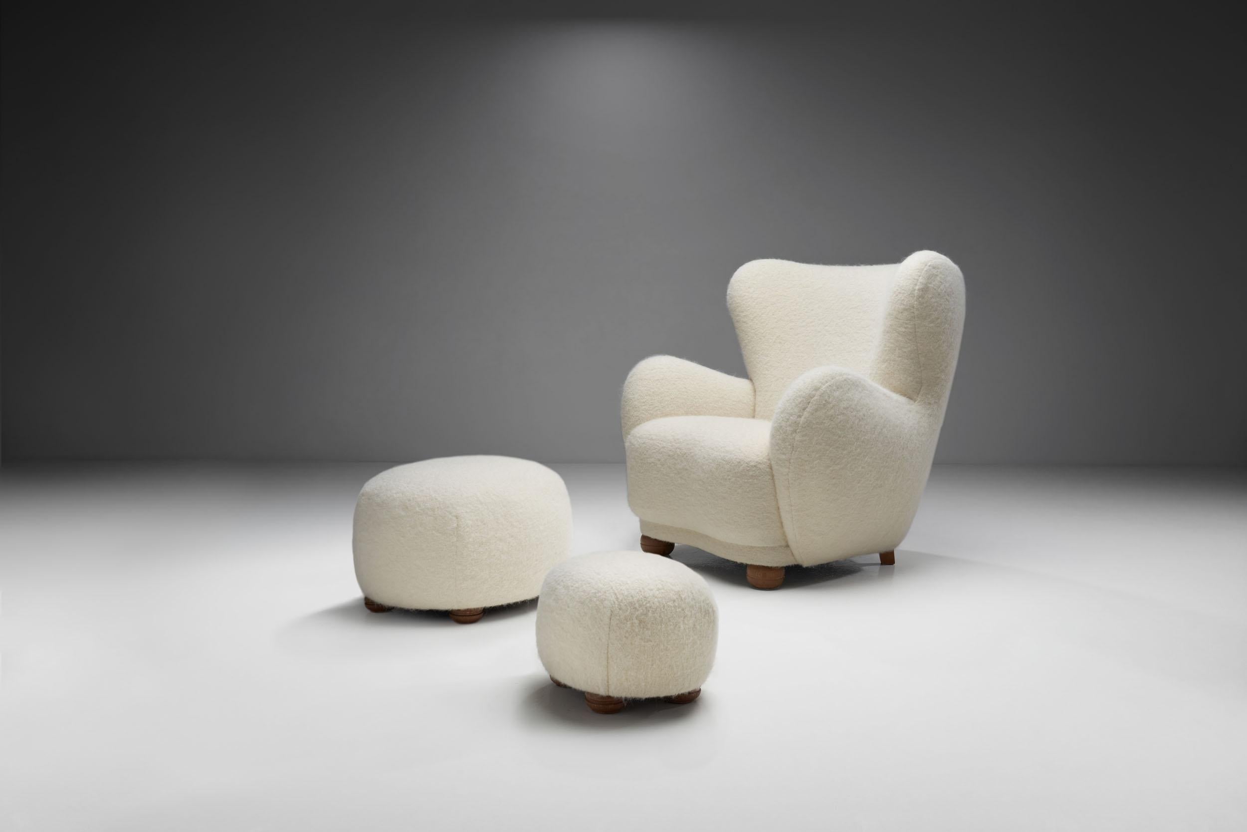 This Danish midcentury lounge chair with the pair of matching ottomans is a great example of the unification of comfort and delicate design elements. 

With its rounded edges, cosy, premium upholstery and soft color, this chair and ottomans are