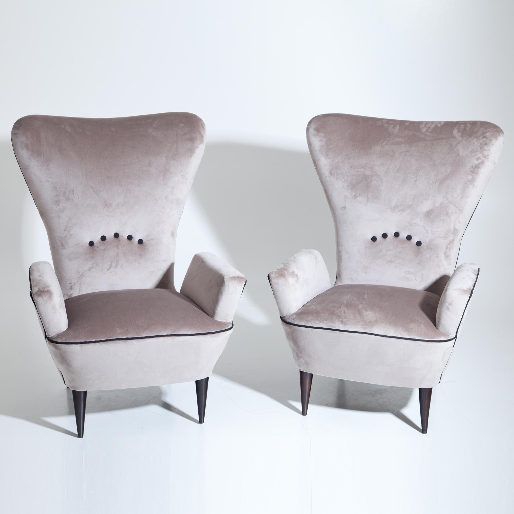Pair of midcentury lounge chairs, attributed to Paolo Buffa, standing on conical black feet with a trapezoidal, tall backrest and armrest that descend towards the backrest. The armchairs were reupholstered with a grey high quality fabric.