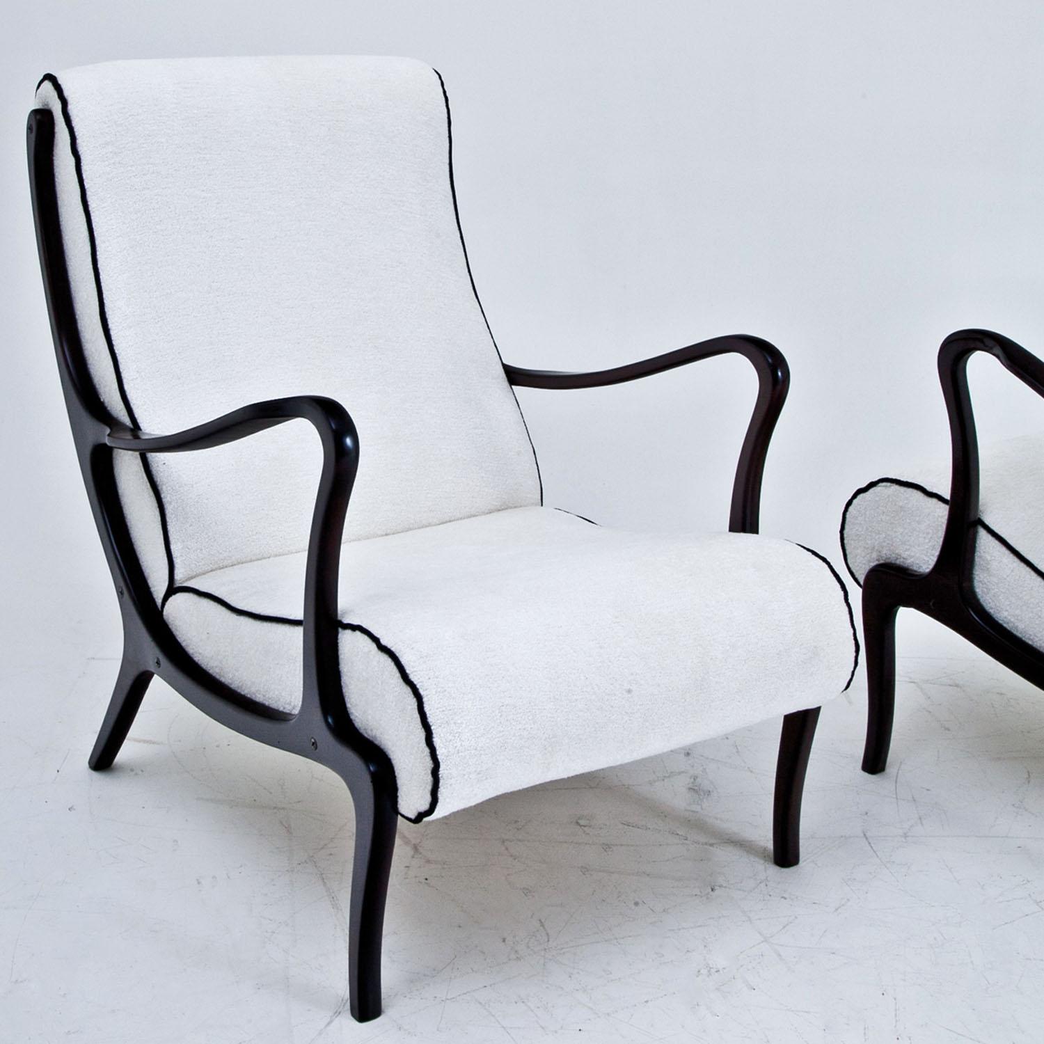 Pair of lounge chairs attributed to Ezio Longhi on slightly bend legs with curved armrests. The seats and backrests were reupholstered with a high quality white fabric with black piping.
