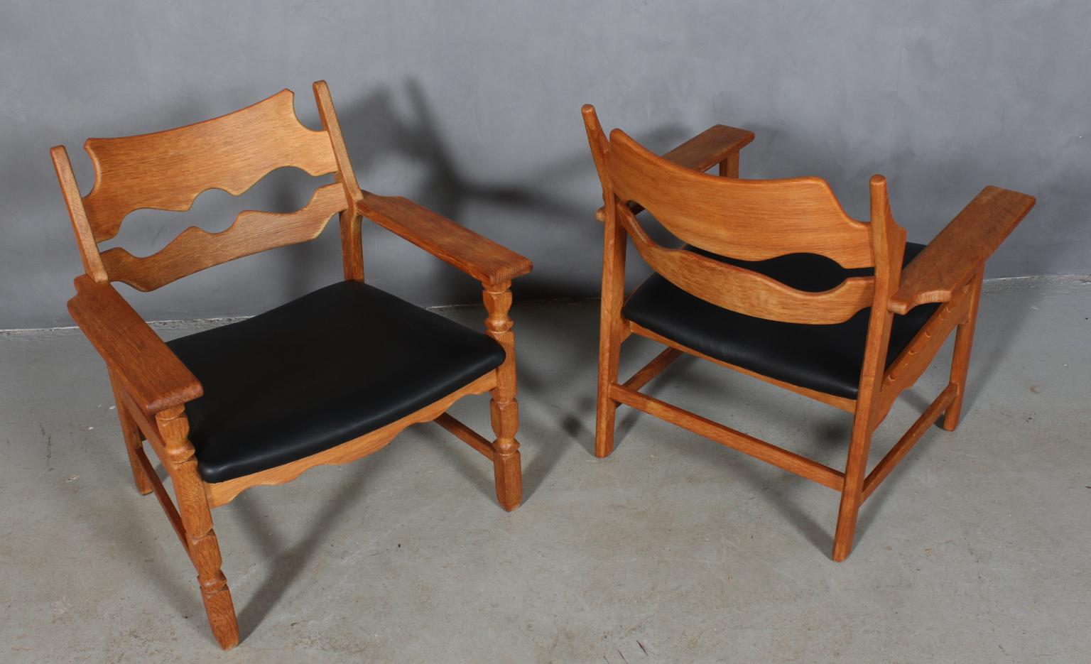 Pair of lounge chairs by Henning Kjærnulf, made of oak and new upholstered with black aniline leather. 

Refreshing design with bold Baroque coming together nicely with Mid-Century Modernism.

Model: Razorblade

Made by EG møbler in the