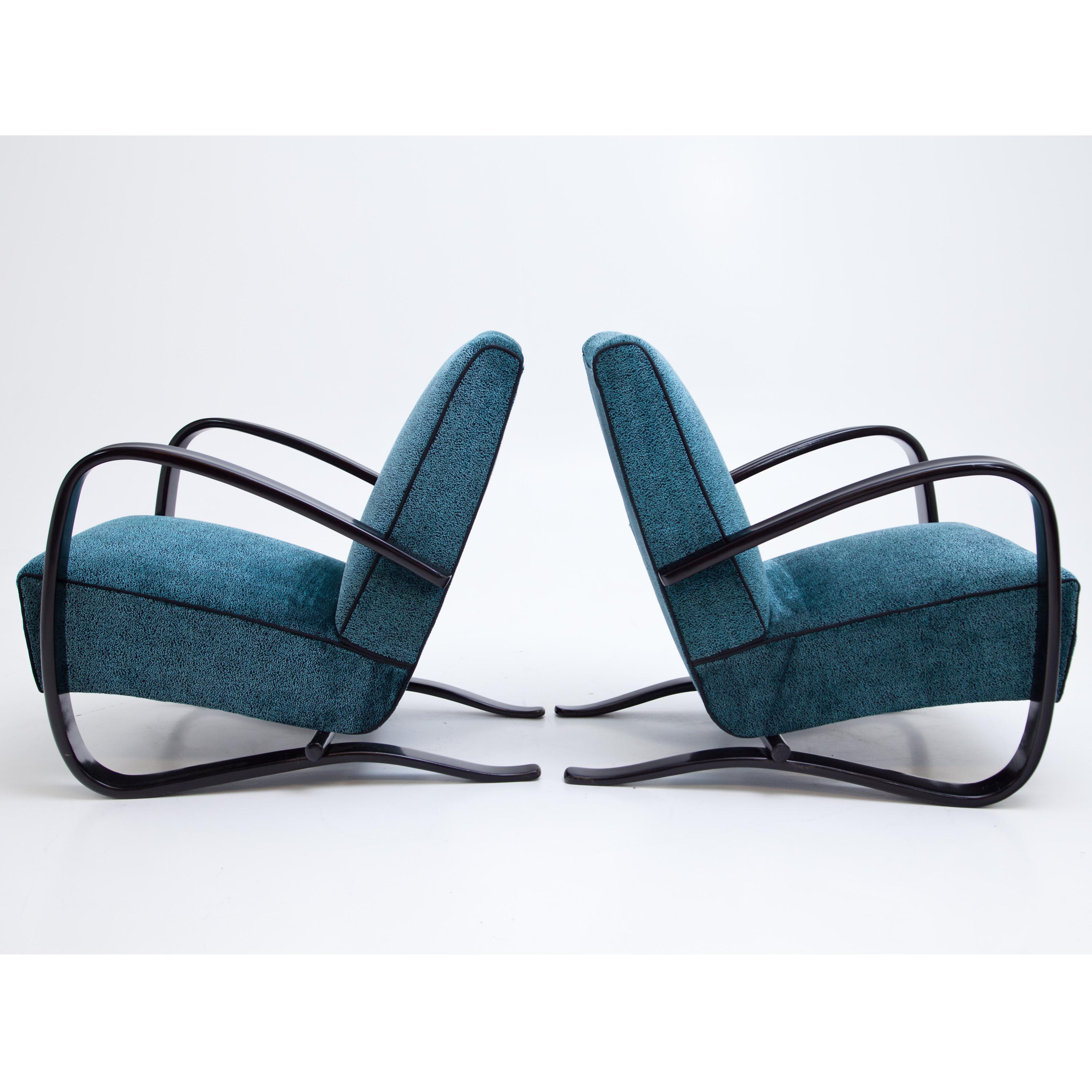 Pair of Halabala armchairs with blue and black upholstery. The dark stained armrests run in an elegant C-shaped curve around the side of the seat cushion and become the supporting frame. The chairs have been reupholstered with a high-quality fabric,