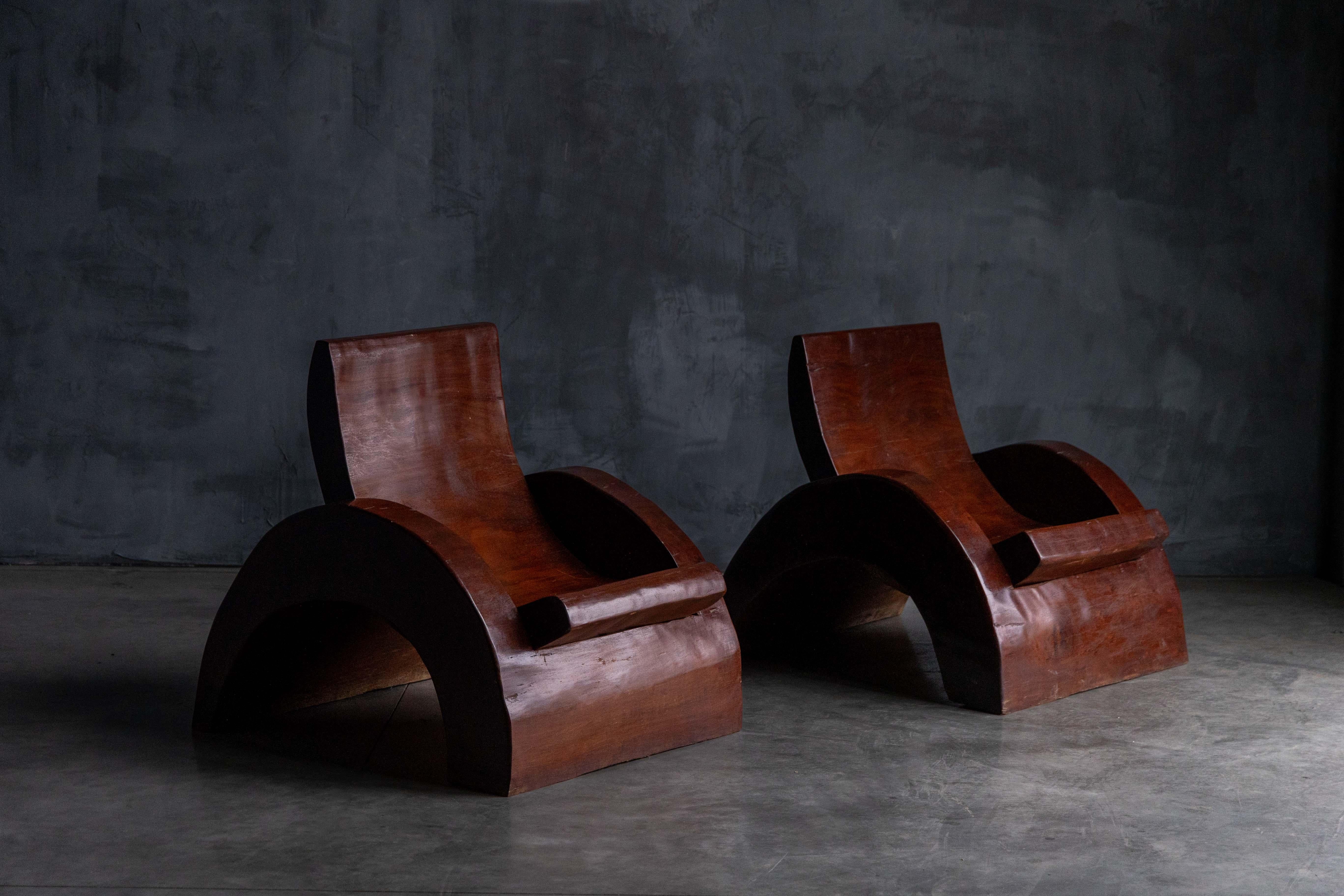 These remarkable lounge chairs, designed by renowned Brazilian architect and designer José Zanine Caldas in the 1970s, exemplifies his mastery of organic minimalism and innovative craftsmanship. Sculpted from richly grained tropical wood, the