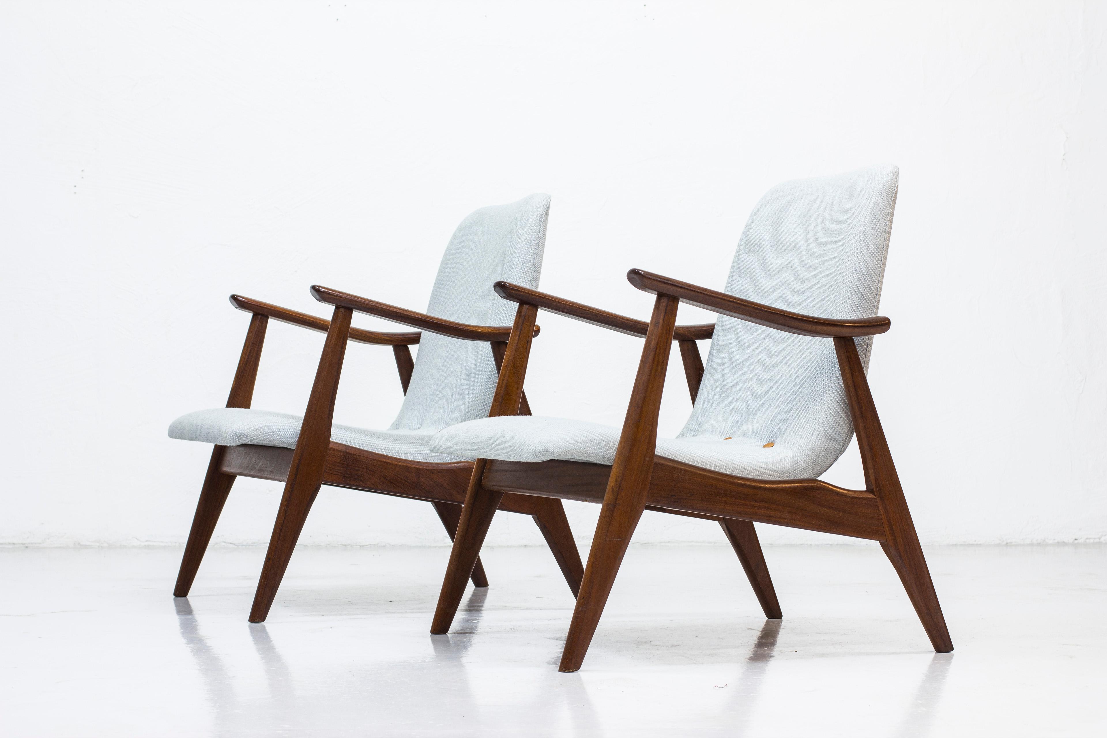 Pair of easy chairs designed by Louis Van Teeffelen. Produced in the Netherlands by WéBé during the 1950s. Frame made from solid afromosia wood and seats reupholstered in grey wool fabric with leather buttons. Good vintage condition with age related