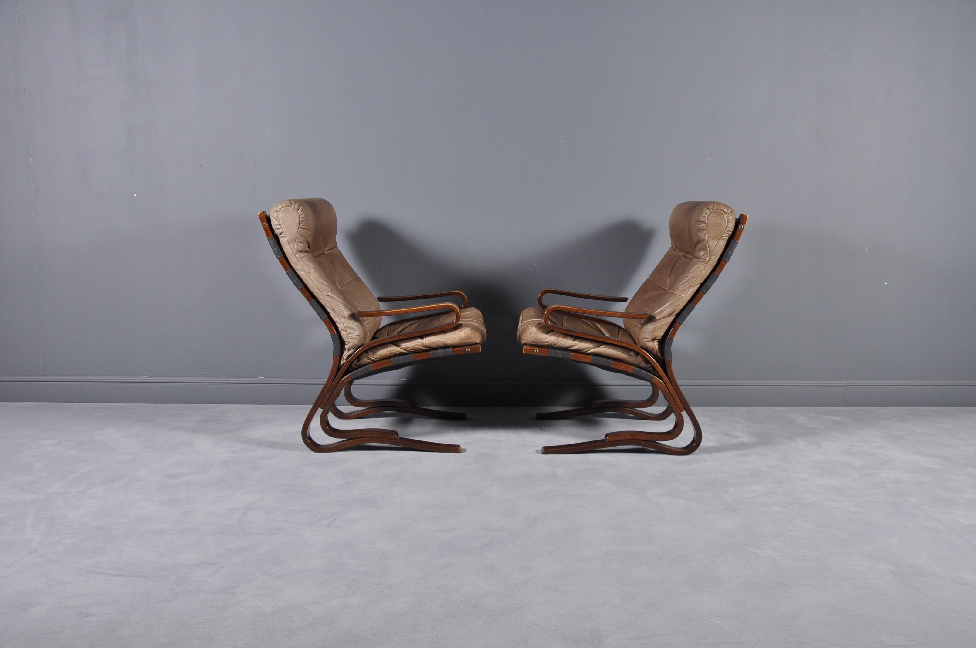 A pair of cognac leather armchairs on a rosewood frame. These were designed by Oddvin Rykken in Norway during the 1970s, and manufactured by Rykken & Co.