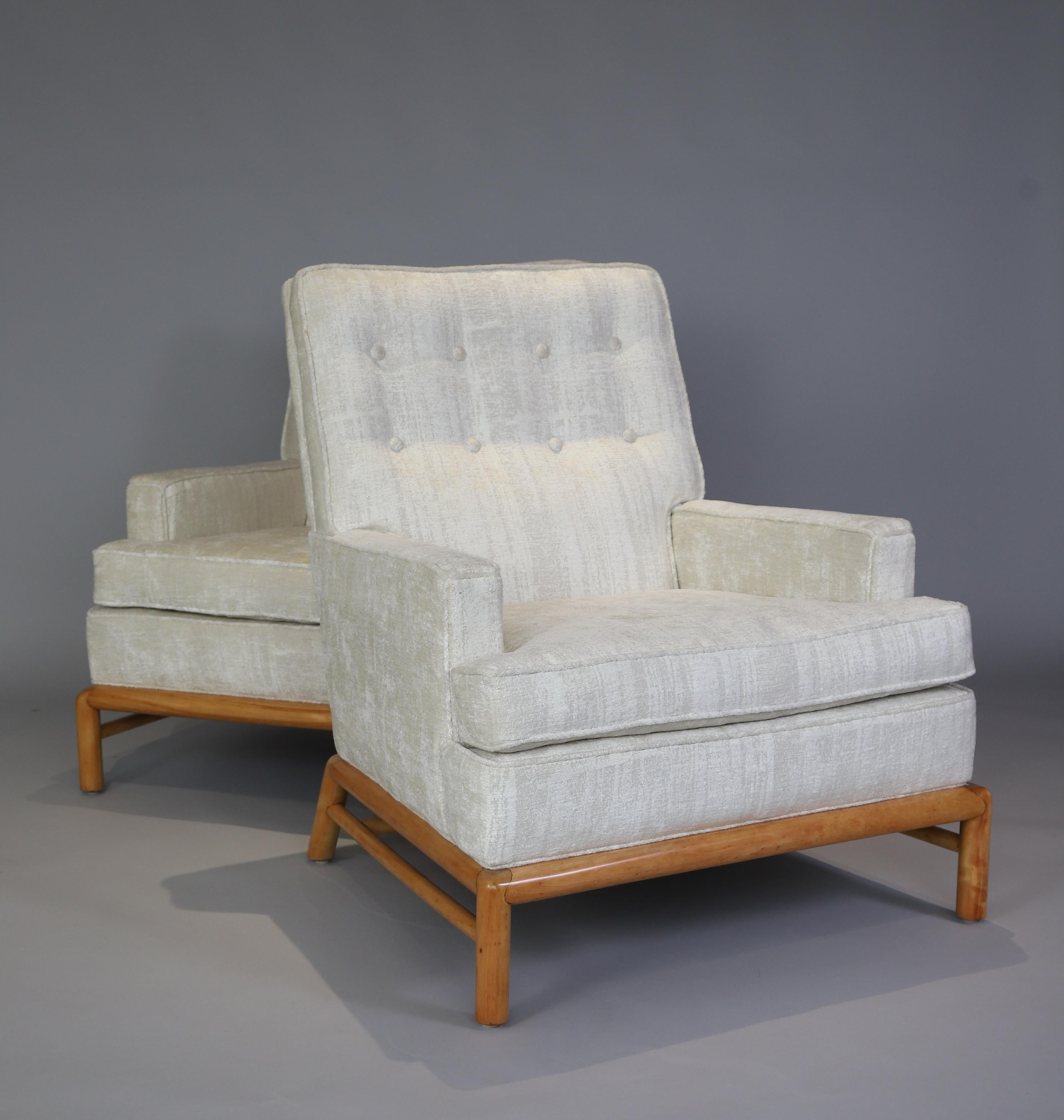Stunning pair of lounge chairs by T.H. Robsjohn Gibbings for Widdicomb Furiture Co. Chairs have been be beautifully re-upholster in a soft white chenille and bases refinished. Original label has been saved and re-attached. Measure: Seat depth is