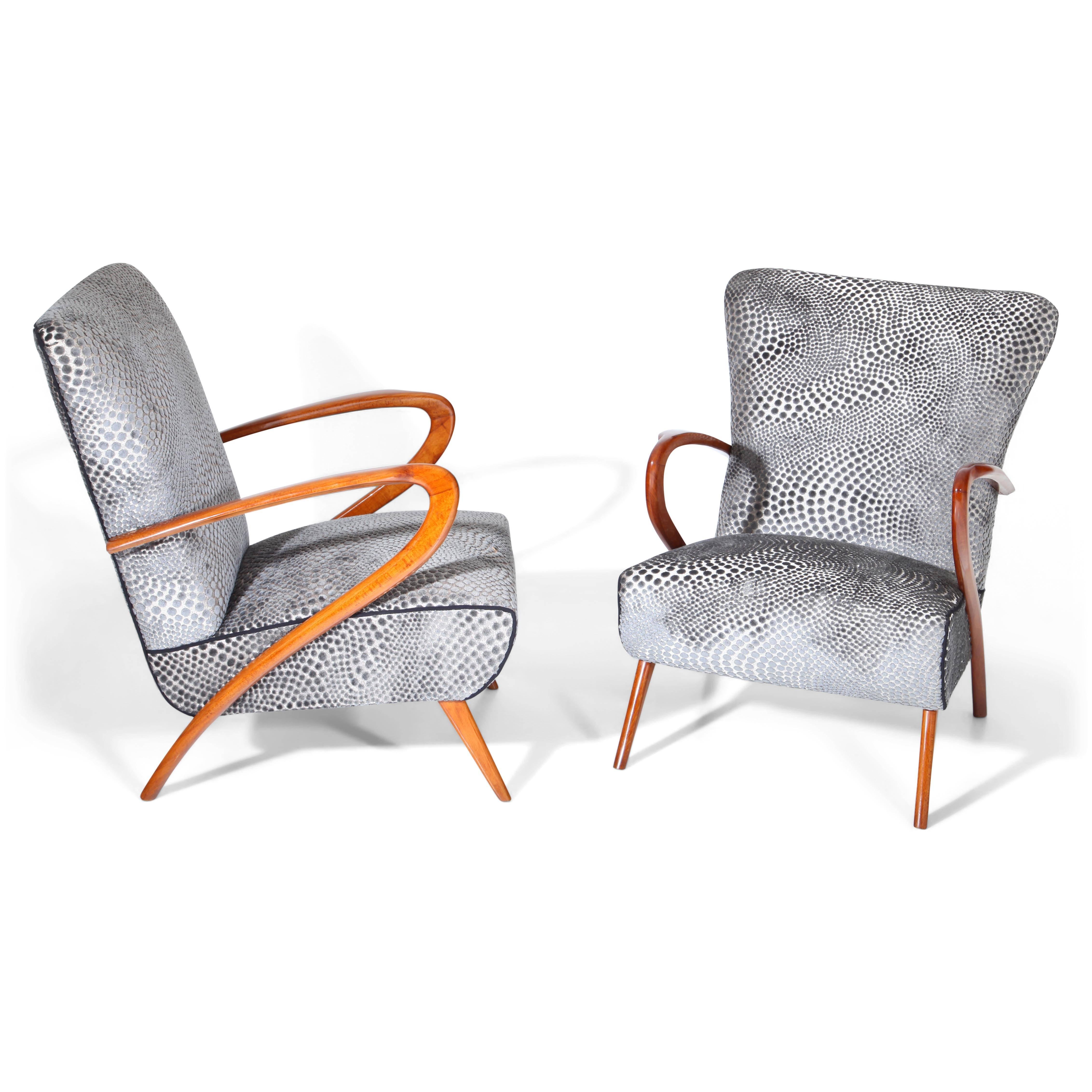 Pair of grey lounge chairs on conical legs with typically bent armrests in the style of Guglielmo Ulrich. Seat and backrest are reupholstered with a structured grey fabric.