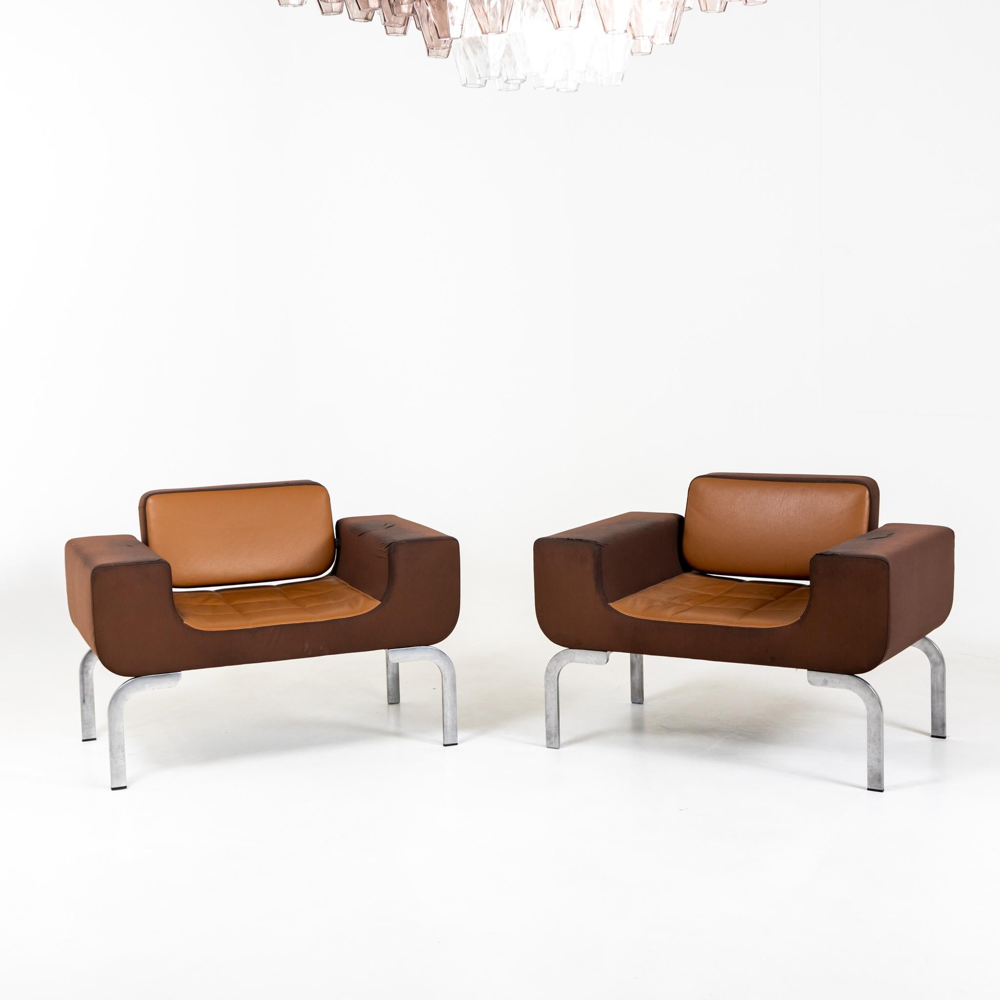 Pair of lounge chairs with brown leather upholstery in original condition.