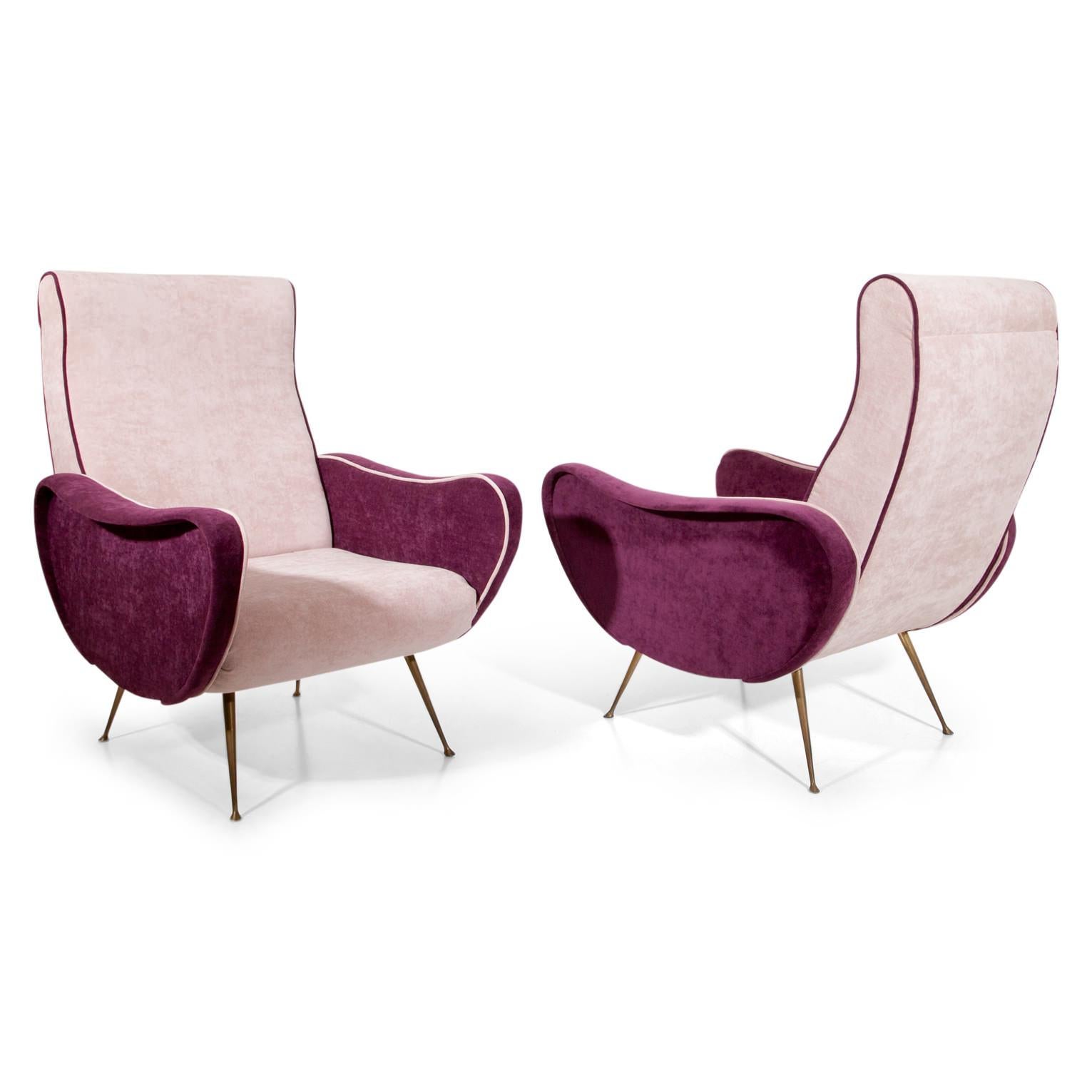 Pair of midcentury lounge chairs, standing on thin brass feet. The kidney-shaped sides were reupholstered with berry-red fabric, the seat and backrest in a soft pink fabric.