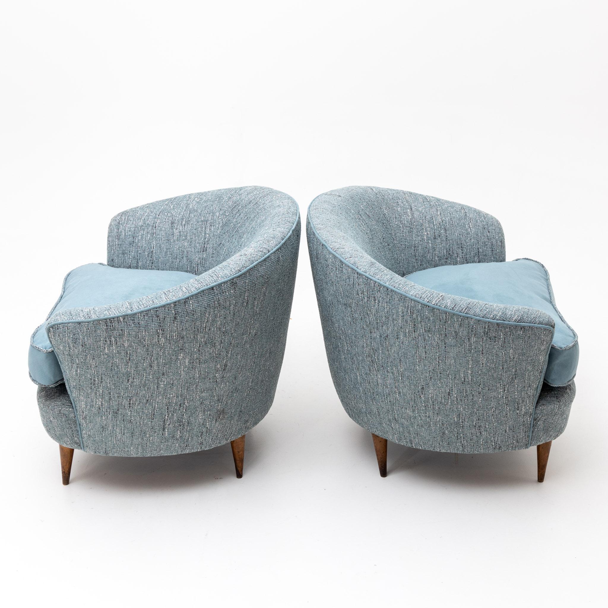 Pair of Italian lounge chairs on conical wooden legs with blue cover and seat cushion, newly upholstered.