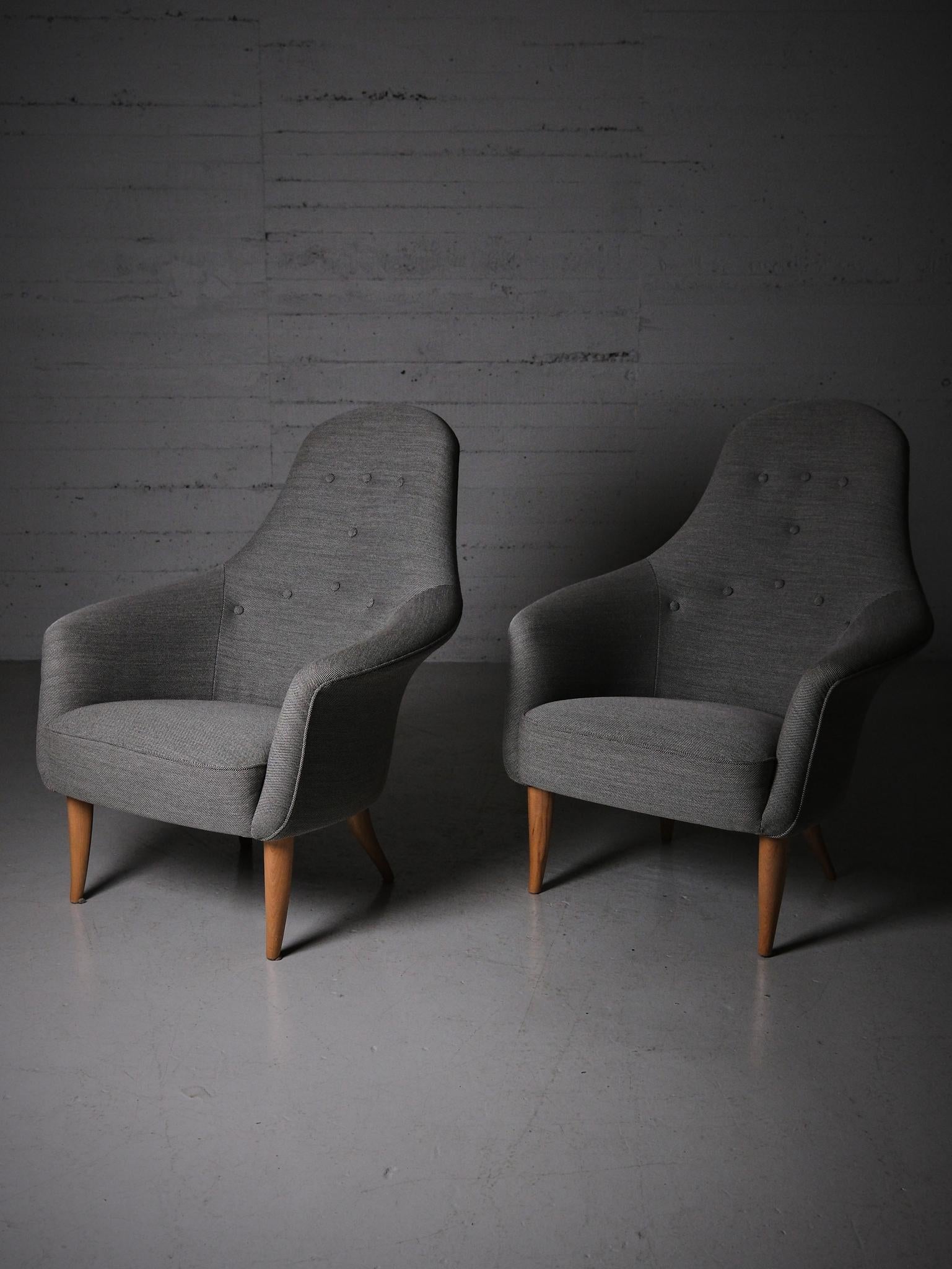 Great pair of lounge chairs designed by Kerstin Hörlin-Holmquist for Nordiska Kompaniet (NK) during the middle of the 20th century. 

Model 'Stora Adam' from NKs 'Triva' series. 

Sculptural legs made of beech and upholstered in a grey fabric. 
