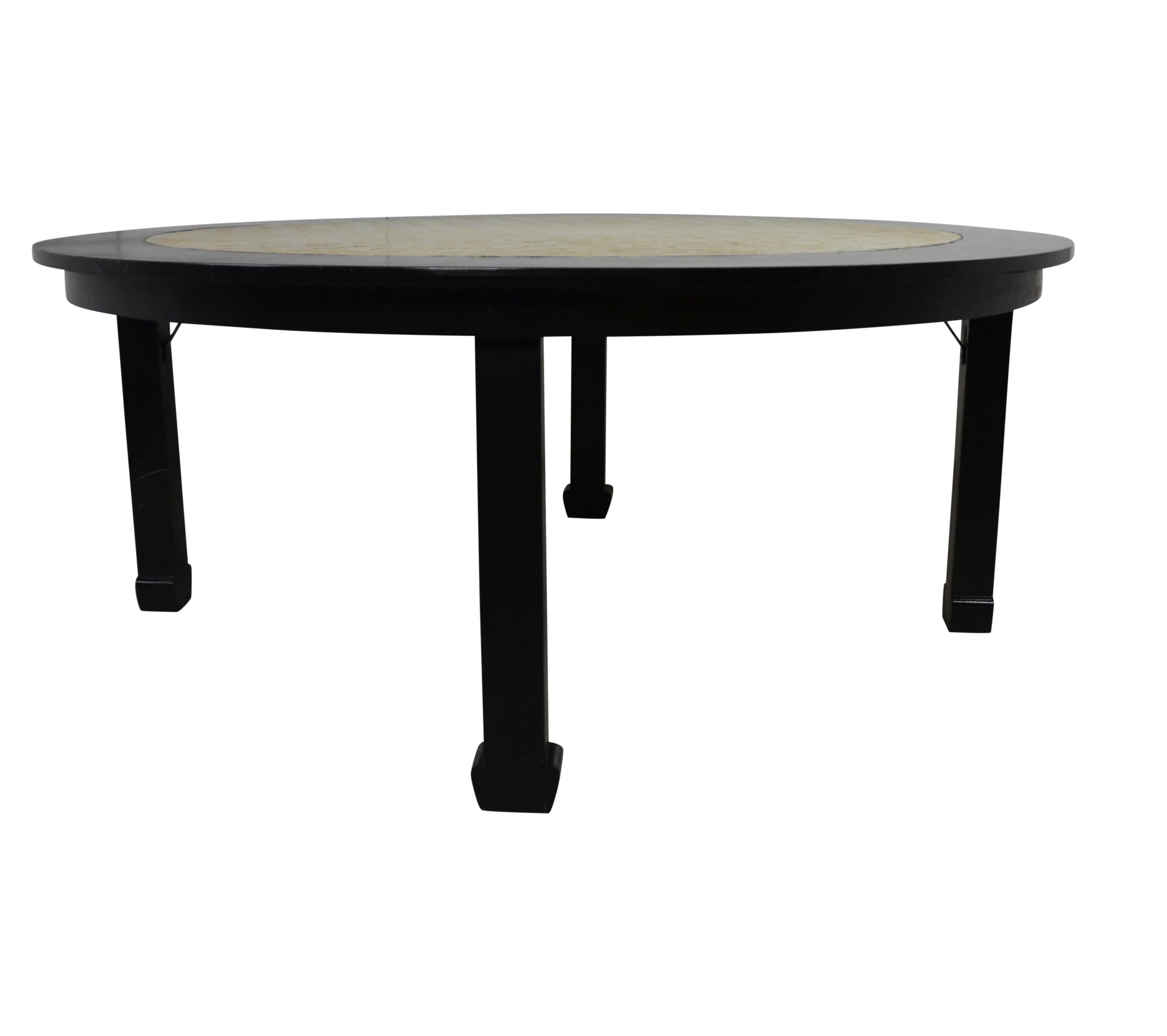 A lounge table and chairs. Finished in an ebony. Center of table is decorated in flat mother of pearl shell-work. Chairs are newly upholstered in linen and feature a brass moving handle to the top/back. Measures: Table 60