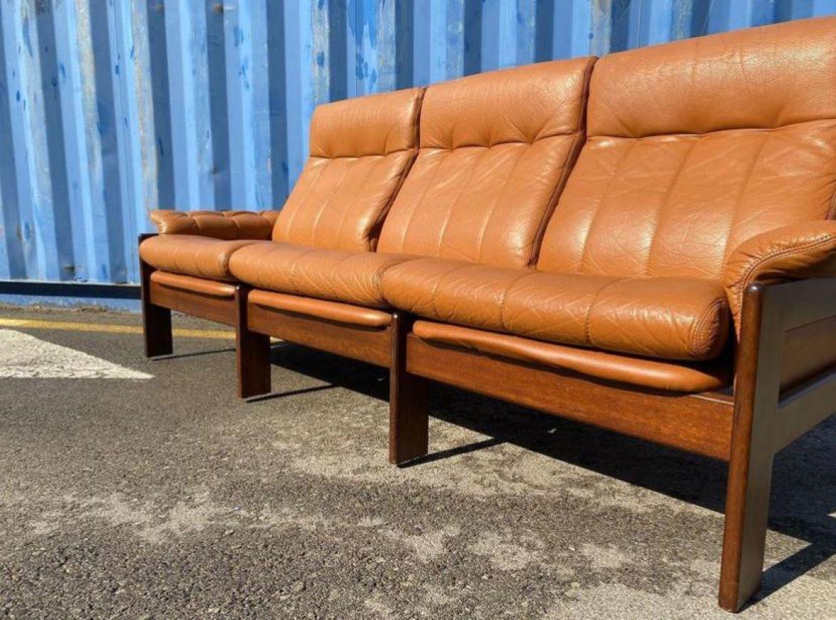 Stunning Mid-Century modern Scandinavian lounge set by Sven Ellekaer for Skippers Mobler A/S Design, 1960s Denmark.

There is a three-seater sofa and one lounge chair. Made of solid Rosewood and brown leather in excellent condition. The lounge