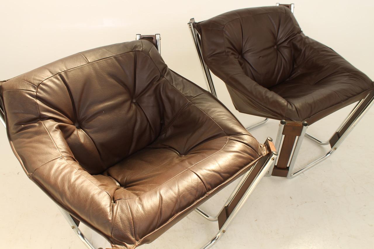 Lounge set in leather. Model SONIC with metal frames and a glass table. 1970s style designed by Odd Knutsen and produced by Hjellegjerde. Table measures 66x42x66 cm.