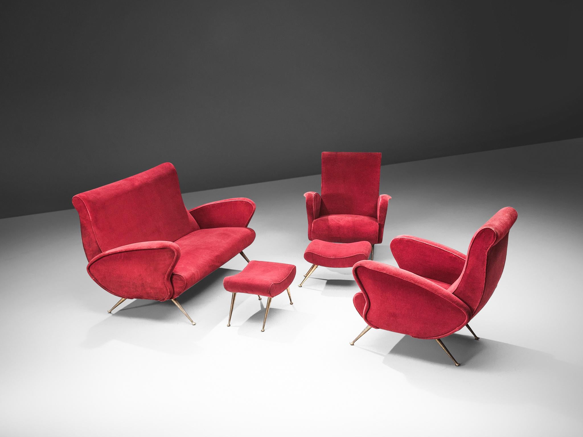 Lounge-Set, roter Samt, Messing, Italien, 1950er Jahre.

Dieses Set ist ein ikonisches Beispiel für italienisches Design aus den fünfziger Jahren. Das organische und skulpturale Zweisitzer-Sofa und die zwei dazu passenden Lounge-Sessel mit Ottomane
