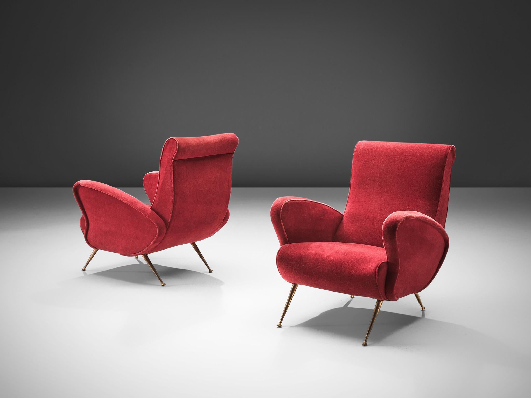 Lounge set, red velvet, brass, Italy, 1950s.

This set is an iconic example of Italian design from the fifties. Organic and sculptural, the two matching lounge chairs is anything but minimalistic. Equipped with the original stiletto brass feet