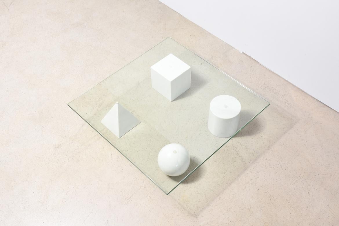 Lounge table Metaphora by Massimo Vignelli for Martinelli Luce, Italy, 1970s. Glass top is on the four geometric shapes square, pyramid, sphere, cylinder, all made of white Carrara marble. Shapes can be distributed individually under the glass
