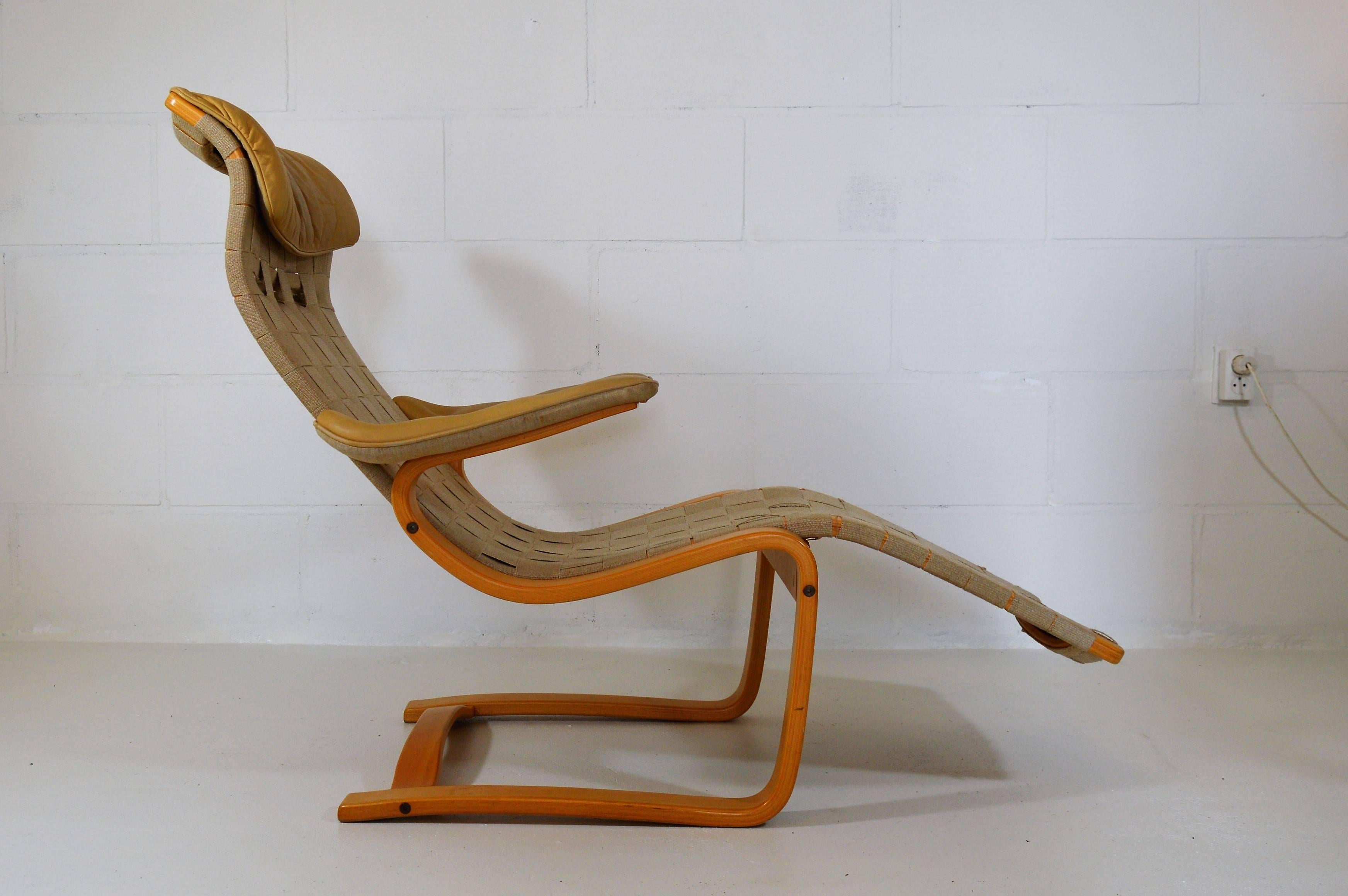 Elegant and very comfortable lounge chair in laminated birch bentwood with original cotton webbing and leather to arms and back pillow, designed by Gustaf Axel Berg (who worked with Arne Jacobsen on the early egg chair design). Stamped at bottom 