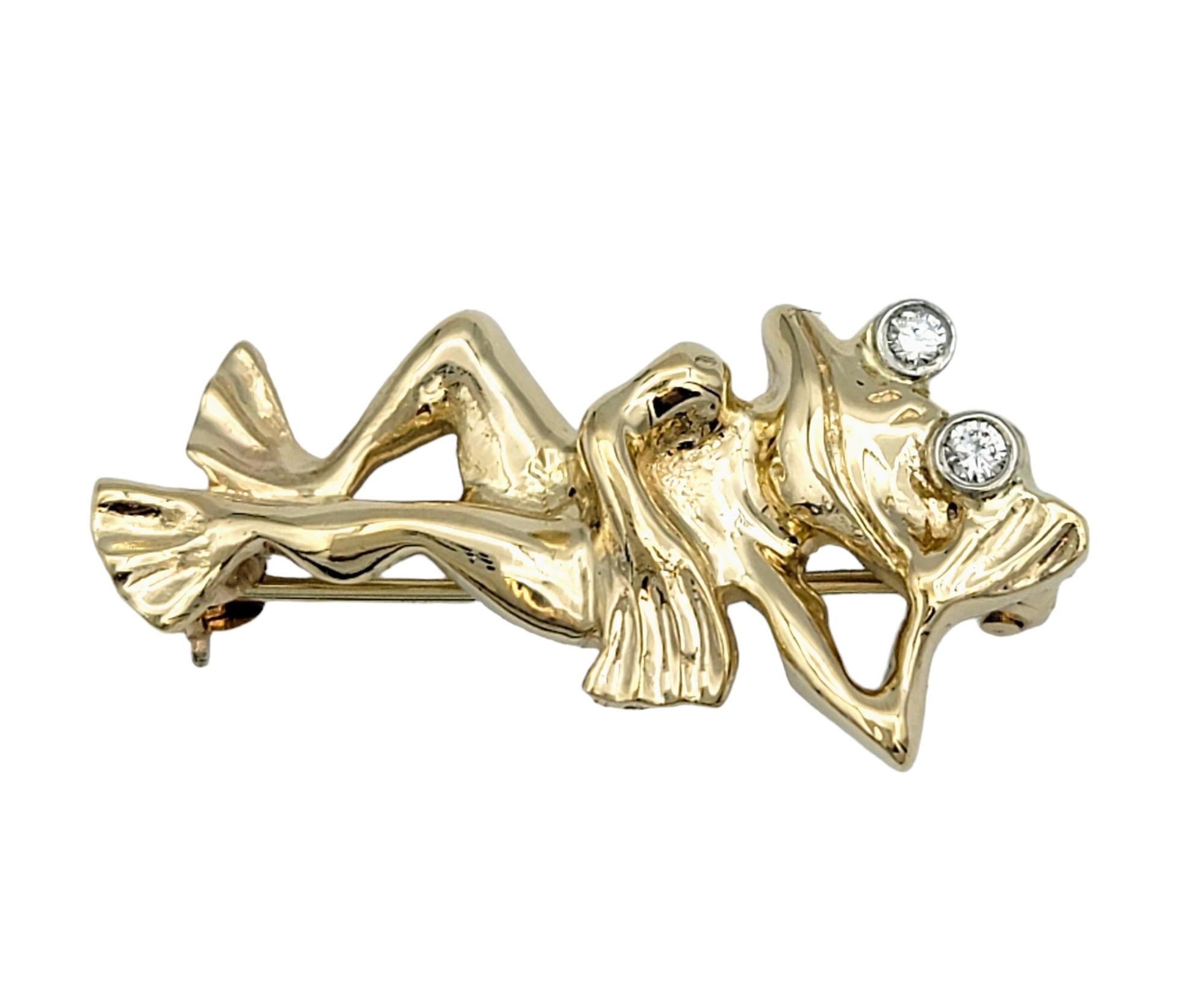 This delightful frog brooch exudes whimsical charm and playful elegance, crafted with meticulous attention to detail in radiant 14 karat yellow gold. The brooch depicts the endearing image of a lounging frog, its graceful pose adding a sense of