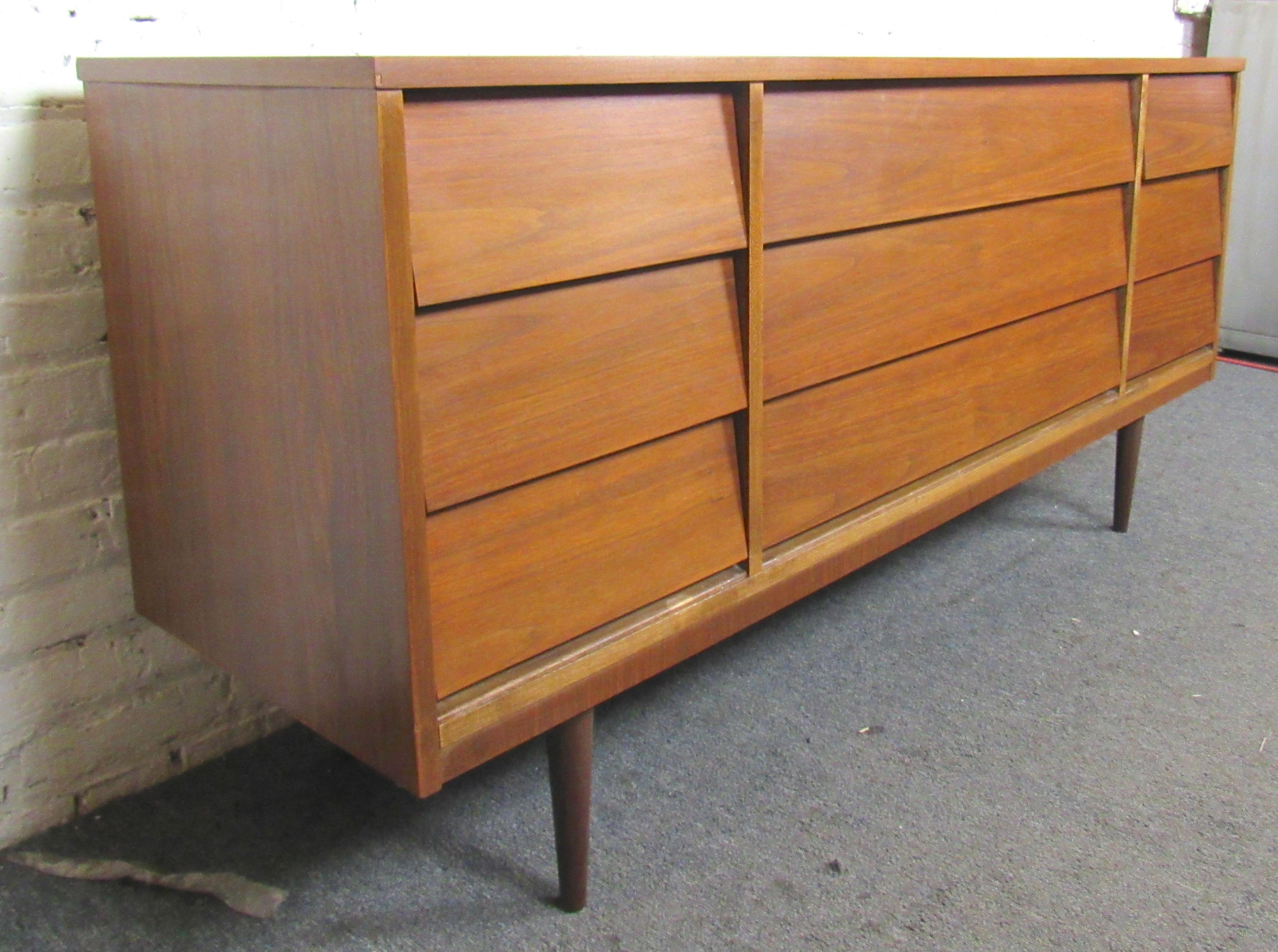 Long nine drawer dresser in walnut by Dixie. Simple mid-century modern lines with unique louvered drawers.
(Please confirm location NY of NJ).