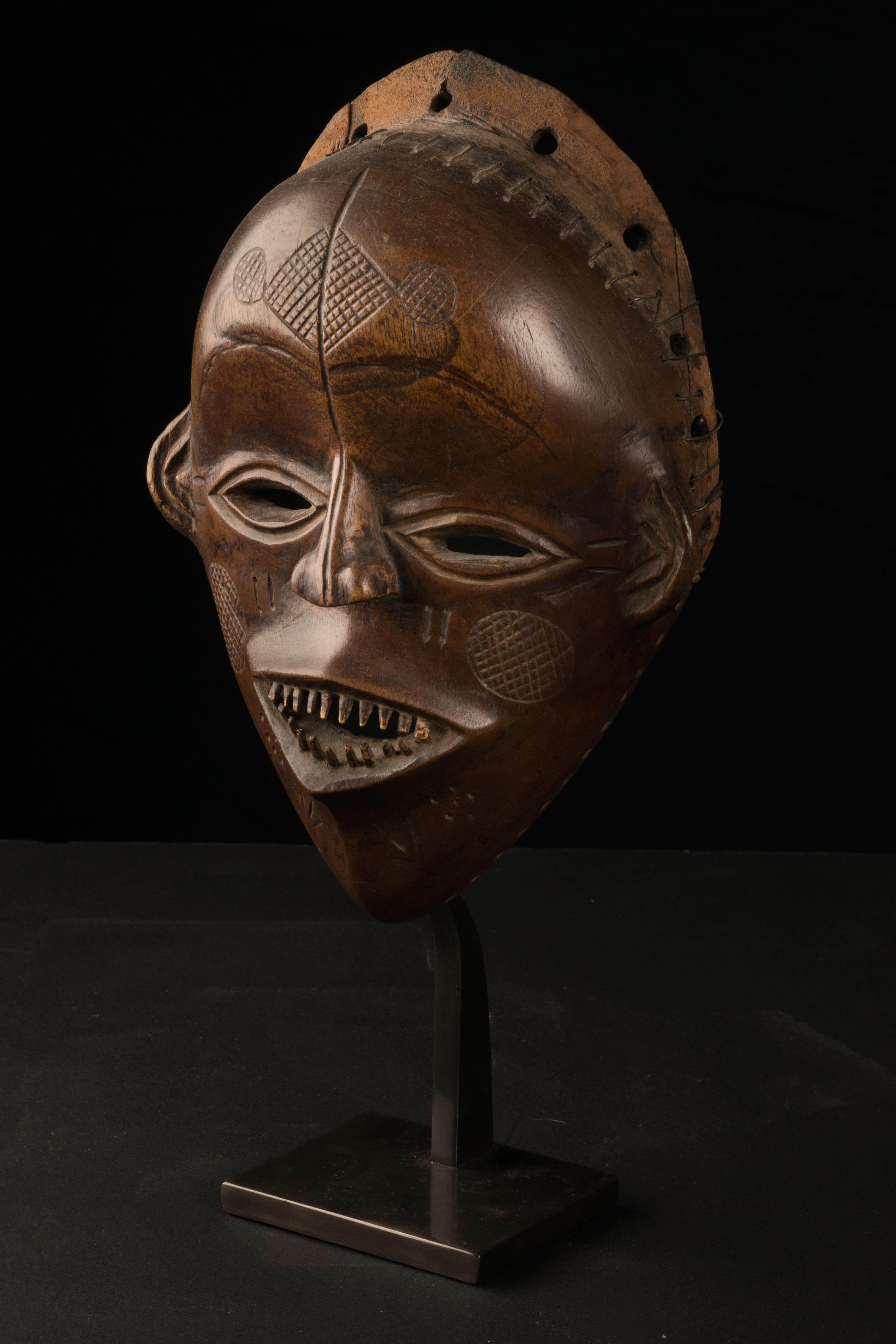 A mask made of hardwood, with an indigenous repair and good usage patina on the outside and the inside... Despite featuring the incised tribal mark of the Chokwe people (so-called ‘Cingelyengelye’) on the forehead, the present mask must be