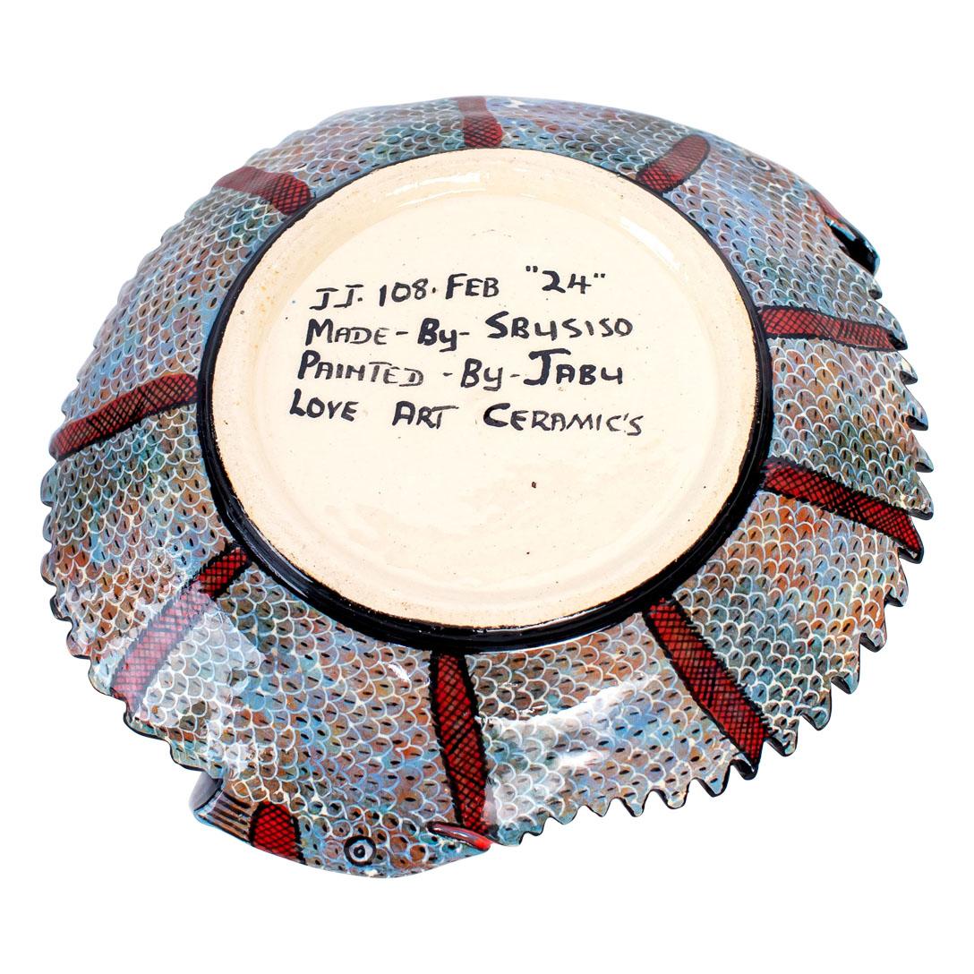 Diese bezaubernde Chamäleon-Münzschale aus Keramik fängt mit ihrem komplizierten Design die Essenz der afrikanischen Tierwelt und Kultur ein. Handbemalt von Jabu Nene und geformt von Nathi im Love Art Ceramic Studio, zeigt es zwei Chamäleons