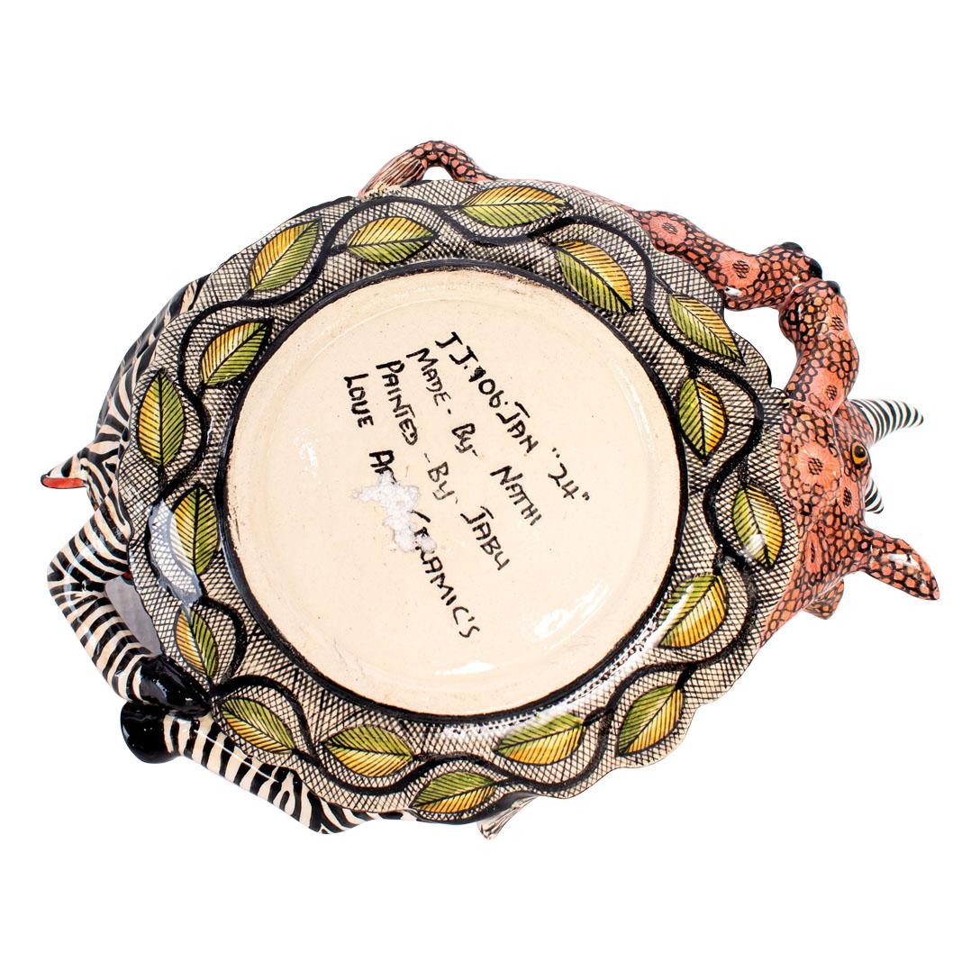 Crafted with care in South Africa, this ceramic Rhino & Zebra coin dish is a tribute to the continent's majestic wildlife. Standing 3 inches high, with a length of 8 inches and a width of 6 inches, it's both practical and ornamental. Hand-painted by