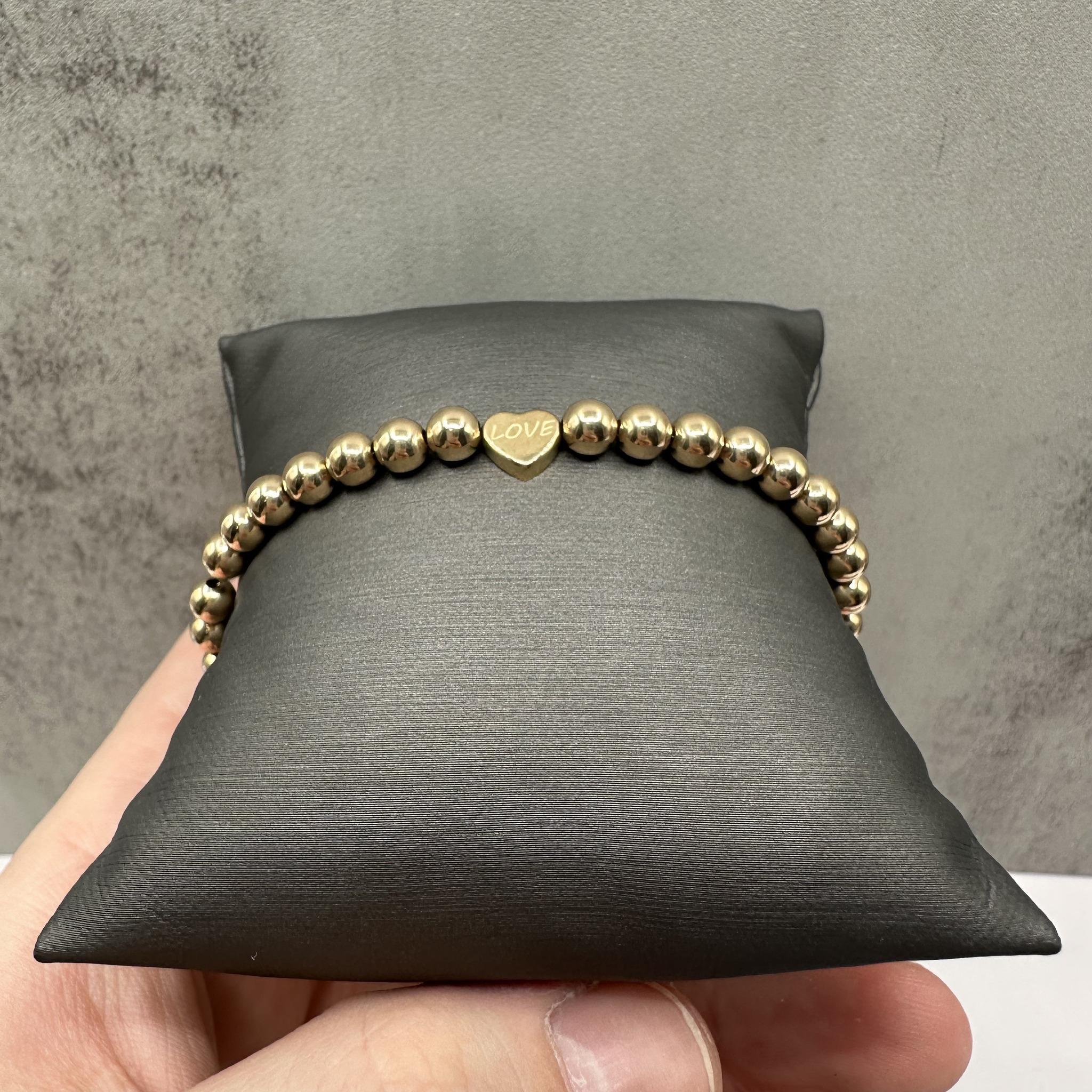 Questo affascinante braccialetto di perline con incisione Love in oro giallo 14kt presenta perline da 5 mm con un sottile disegno 